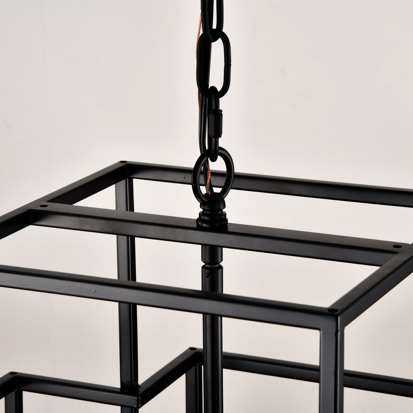 Close up of black metal cage chandelier frame with hanging chain detail