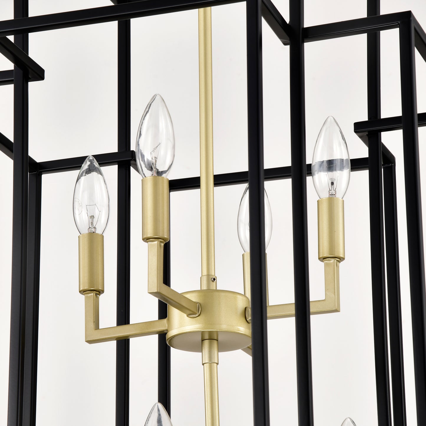 Black and brass geometric foyer chandelier with four clear candle bulbs visible