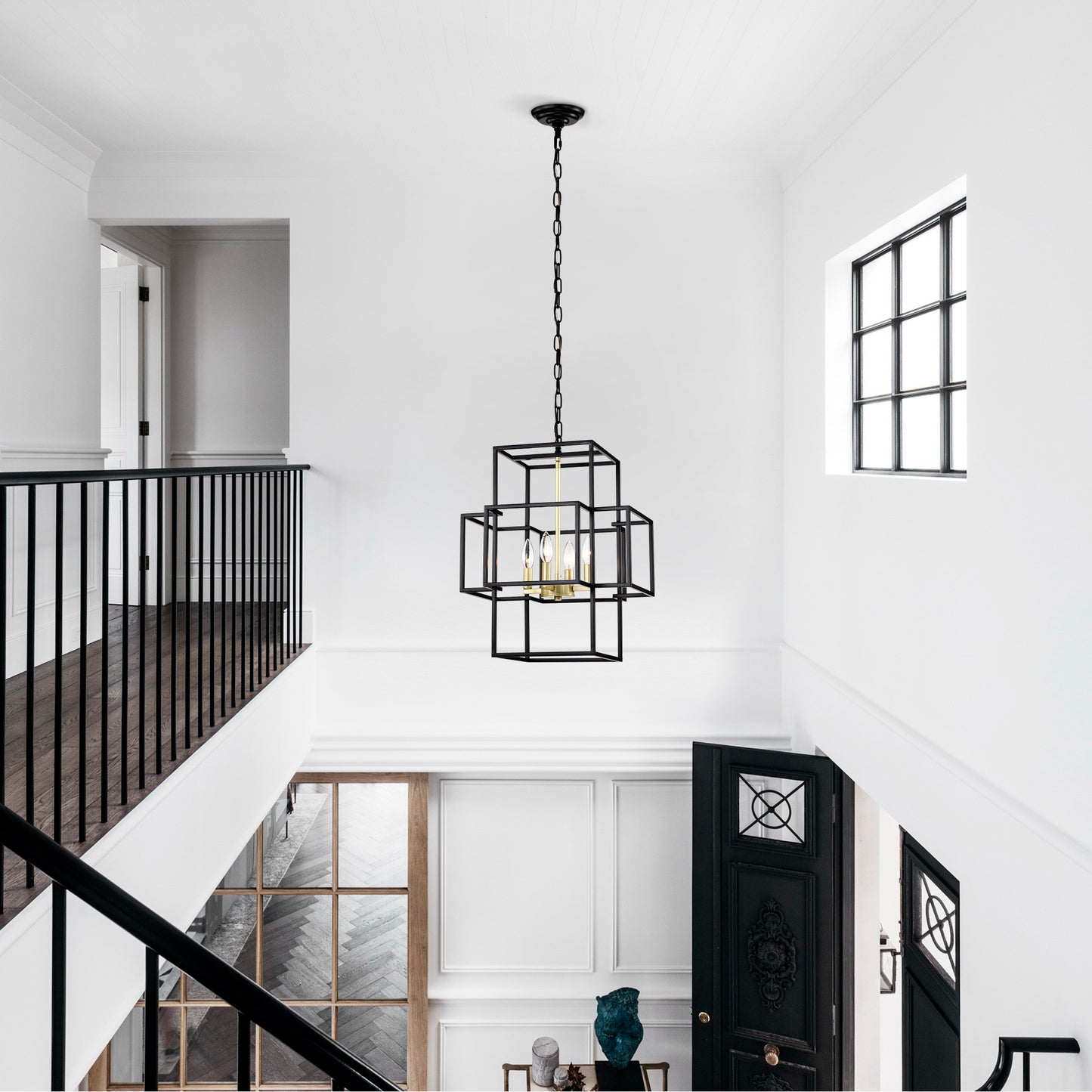 Geometric black metal chandelier with gold accents illuminating a modern foyer with chain suspension