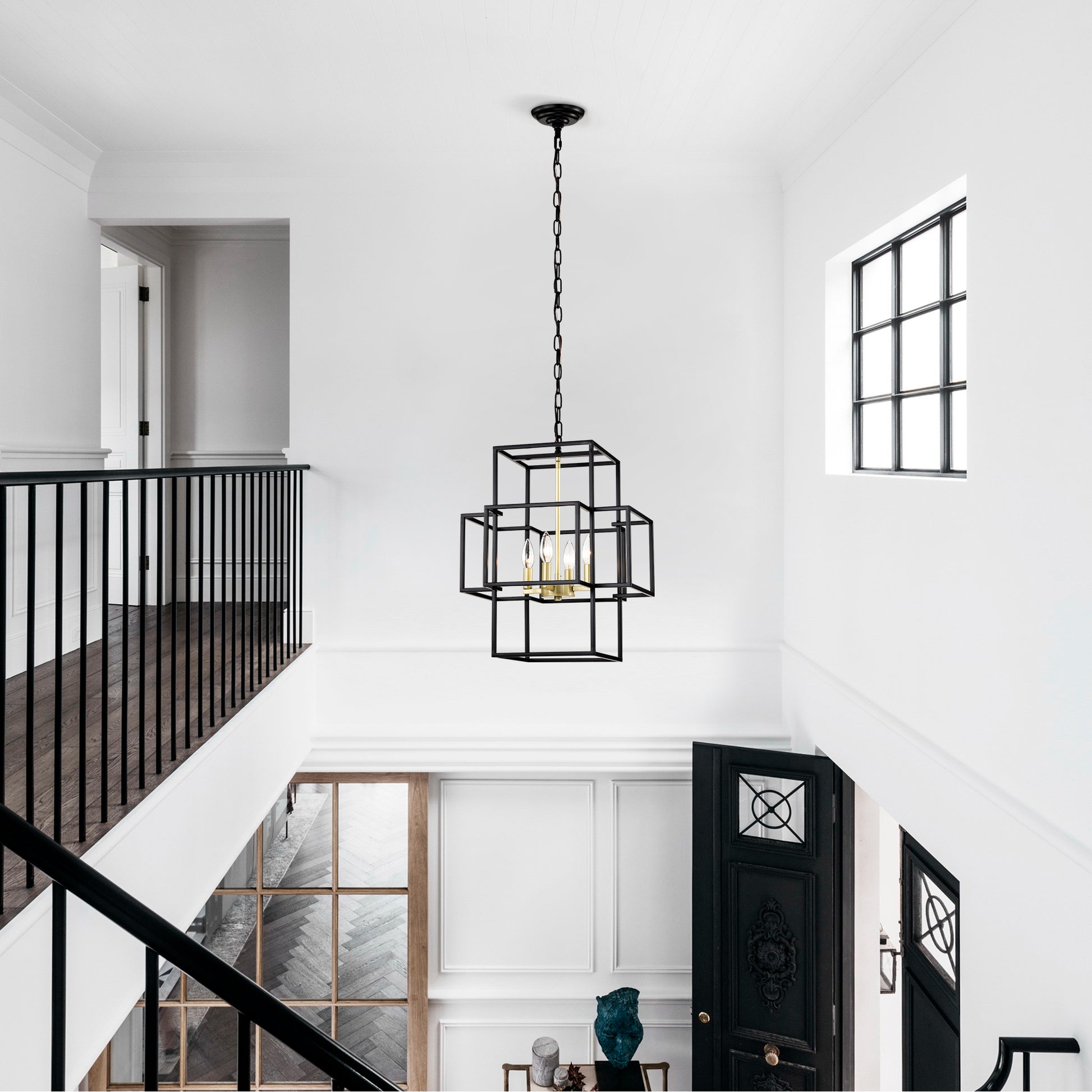 Geometric black metal chandelier with gold accents illuminating a modern foyer with chain suspension