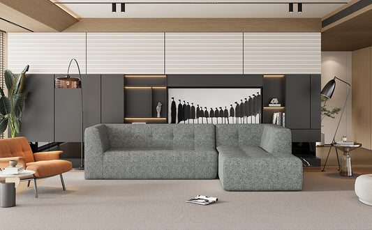 Modern grey sectional sofa with plush fabric upholstery in a minimalist living room