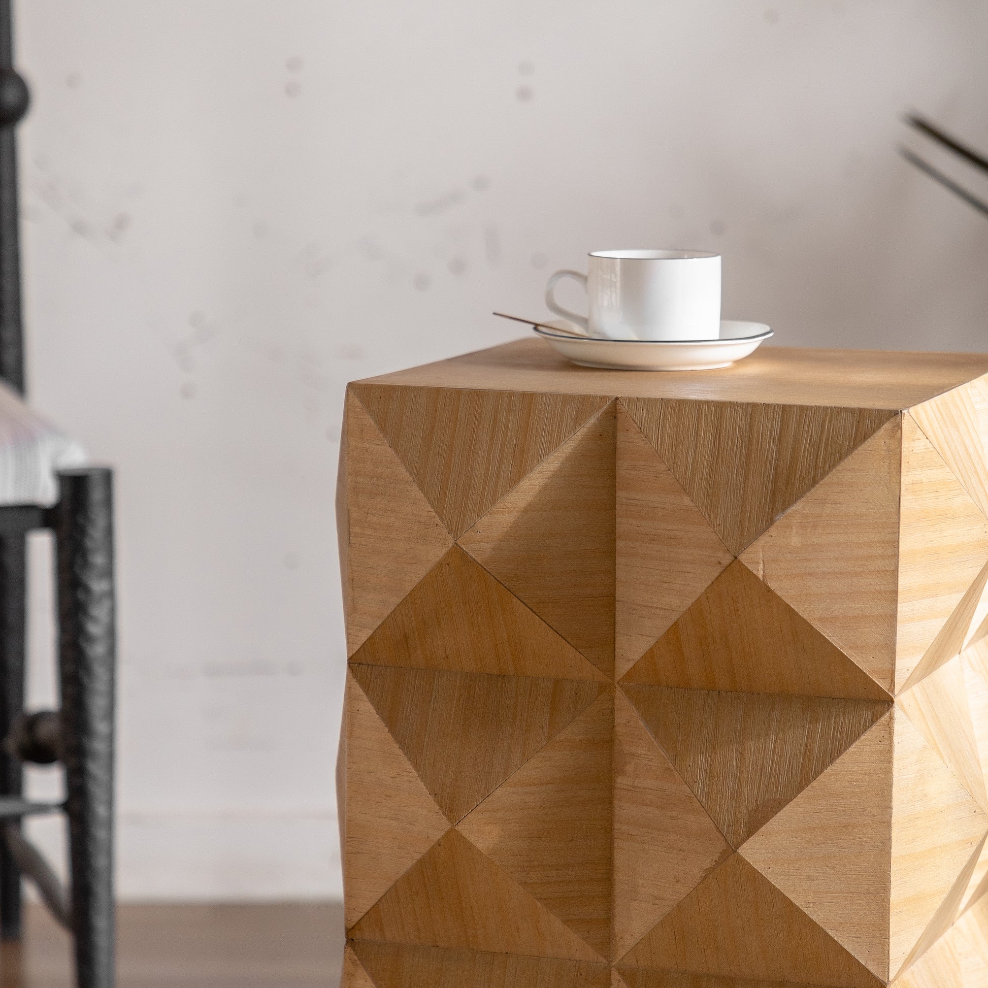 Geometric wood side table with faceted natural wood finish and white ceramic mug