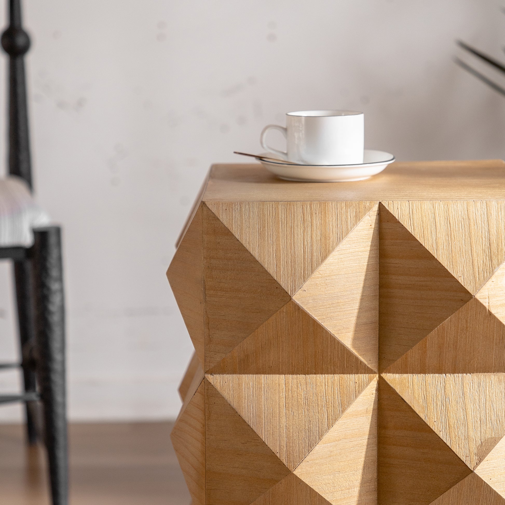 Geometric light oak side table with faceted design complementing modern decor