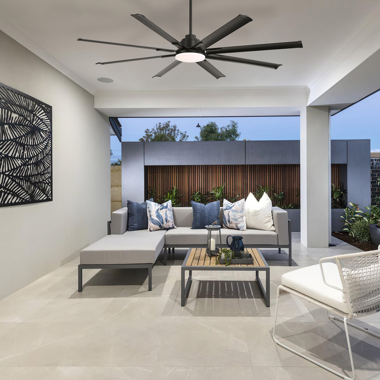 Modern outdoor sectional sofa in light gray with dark metal frame and floral accent pillows