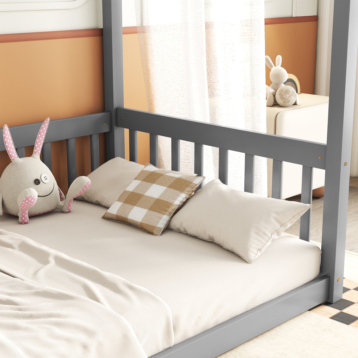 Gray canopy bed frame with plush bedding and stuffed bunny toy