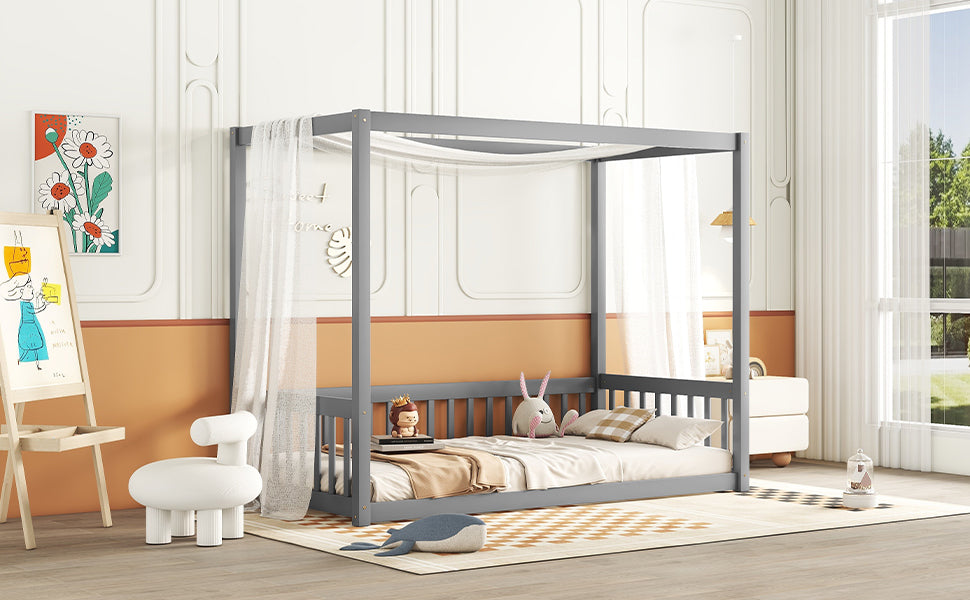 Grey wooden canopy bed with sheer drapes for a childs bedroom