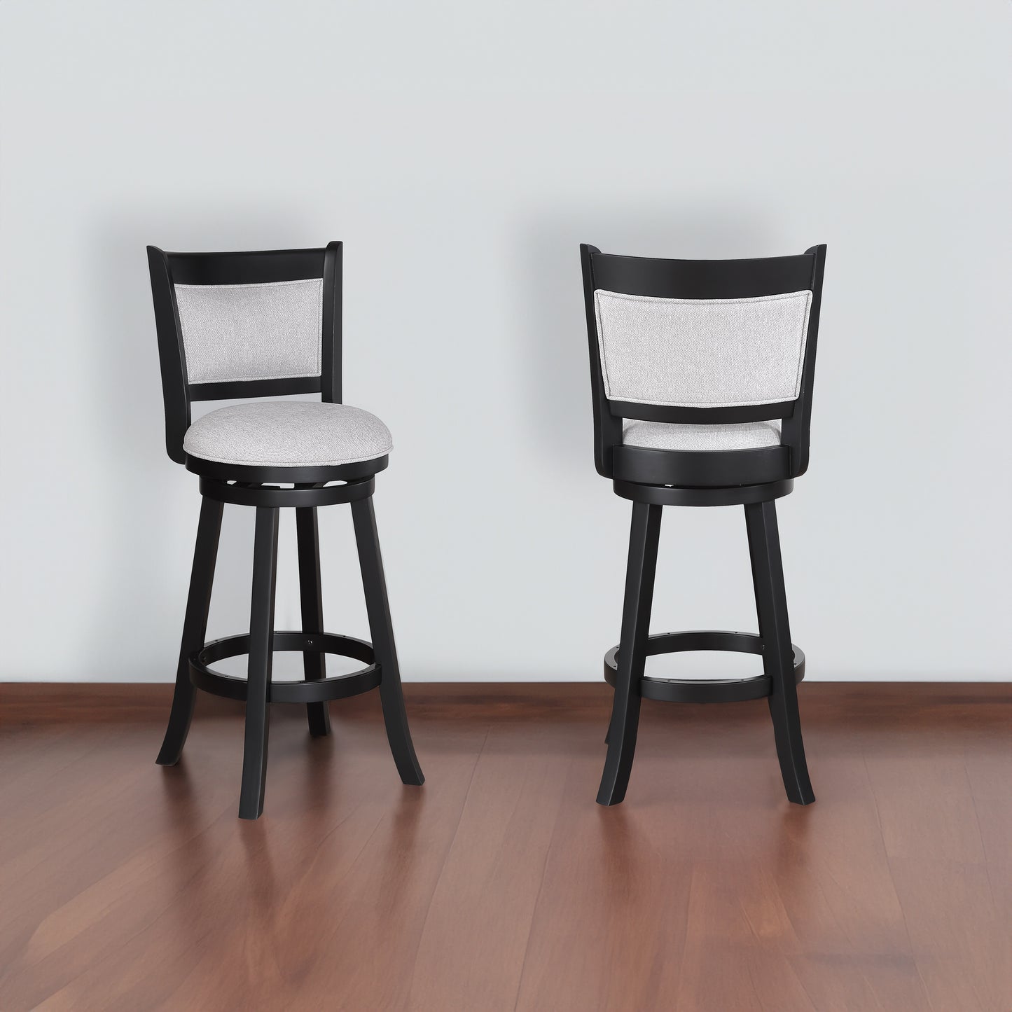 Two black swivel bar stools with light grey upholstered seats and backs