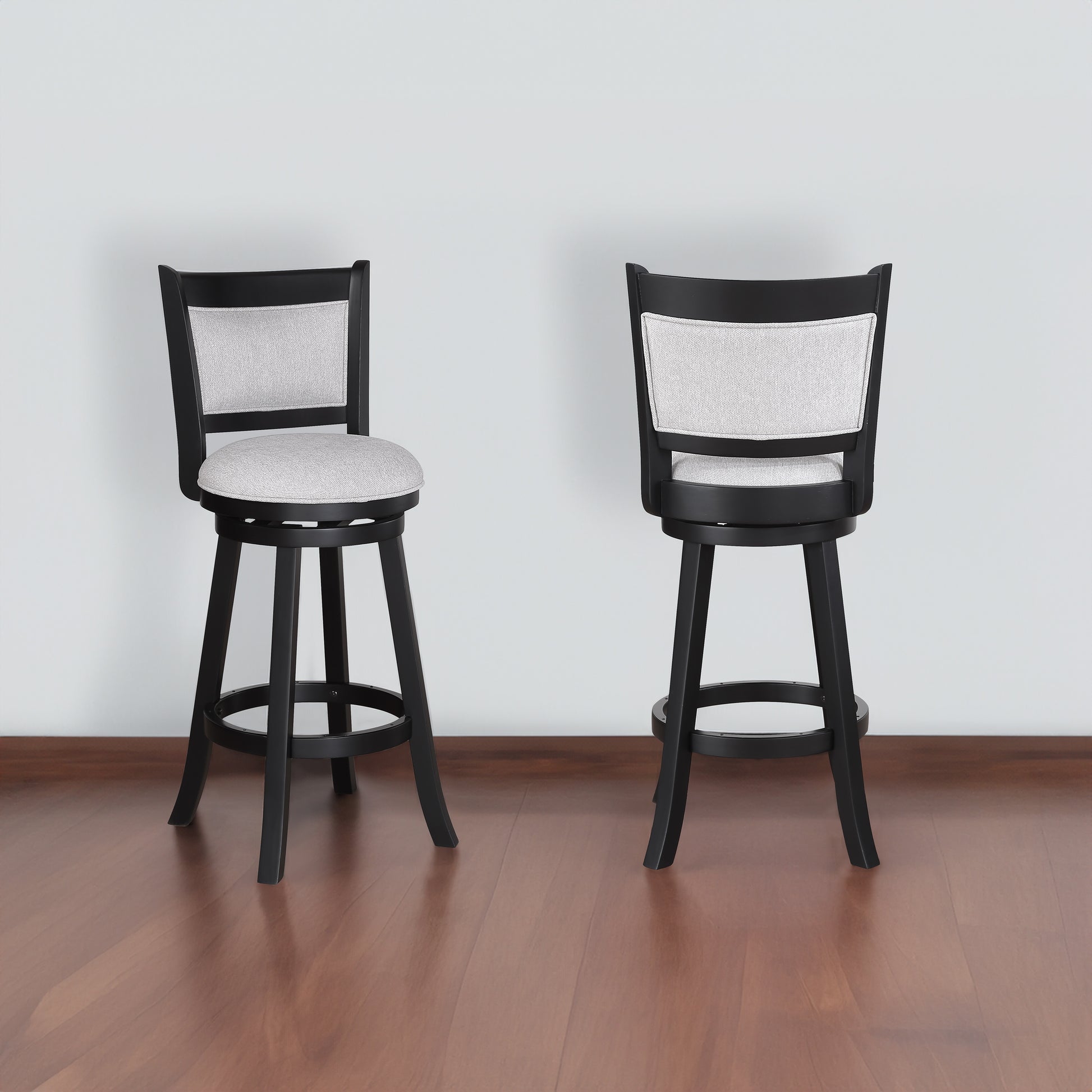 Two black swivel bar stools with light grey upholstered seats and backs