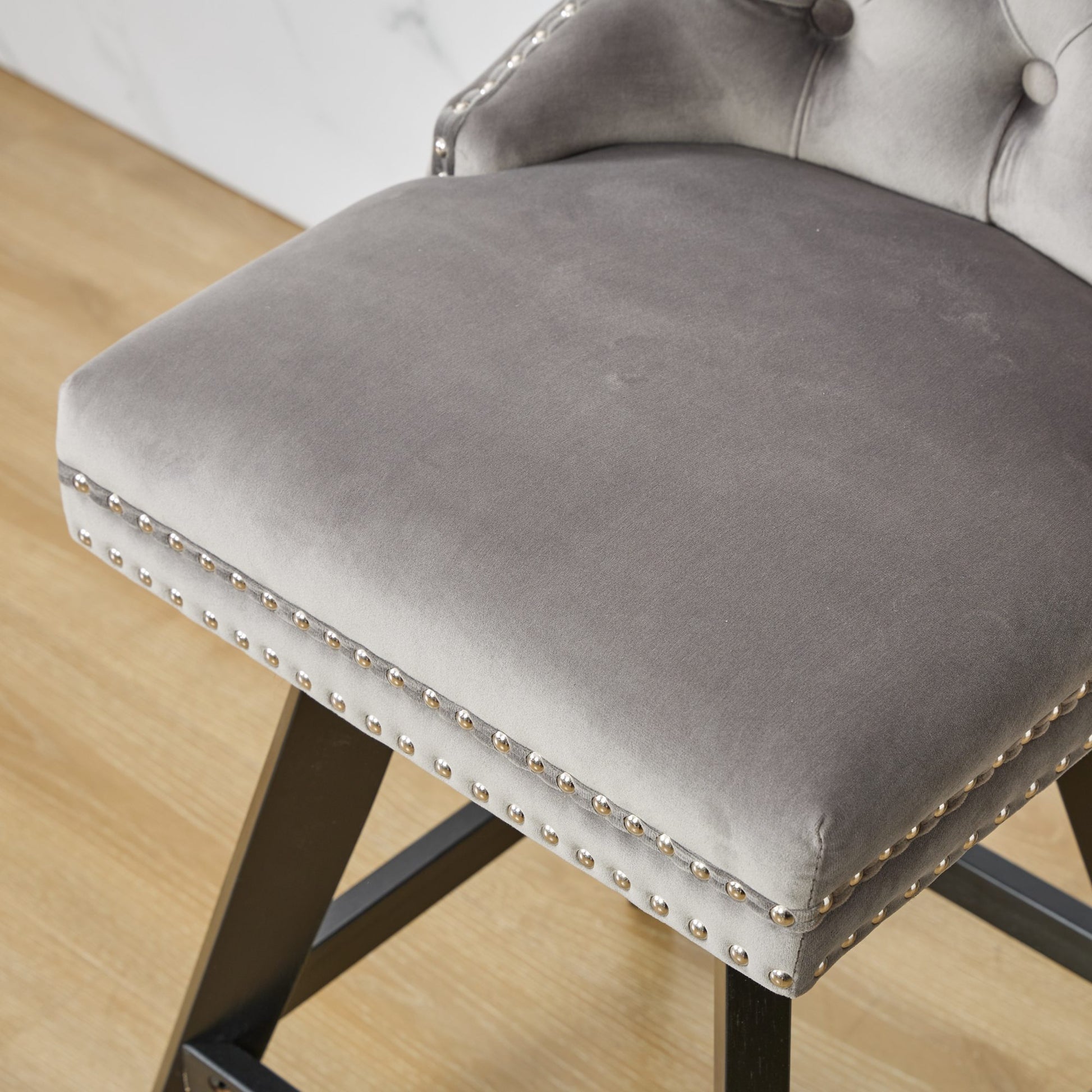 Grey velvet bar stool with button tufting and silver nailhead trim