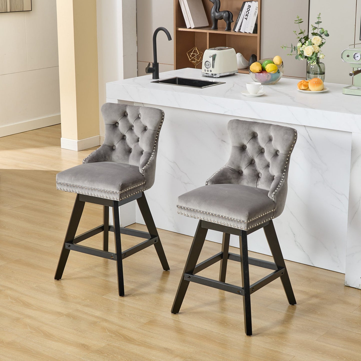 Tufted grey velvet bar stool with silver nailhead trim and black wood legs