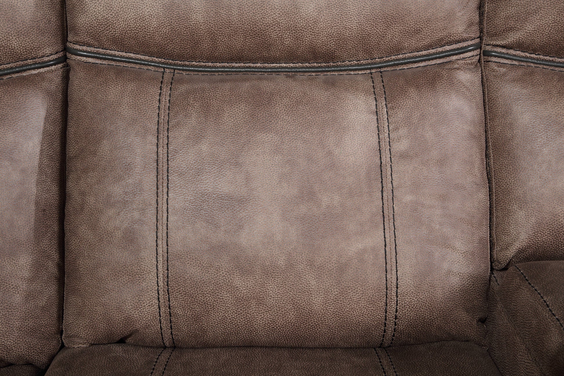 Closeup of a plush brown recliner seat with detailed stitching