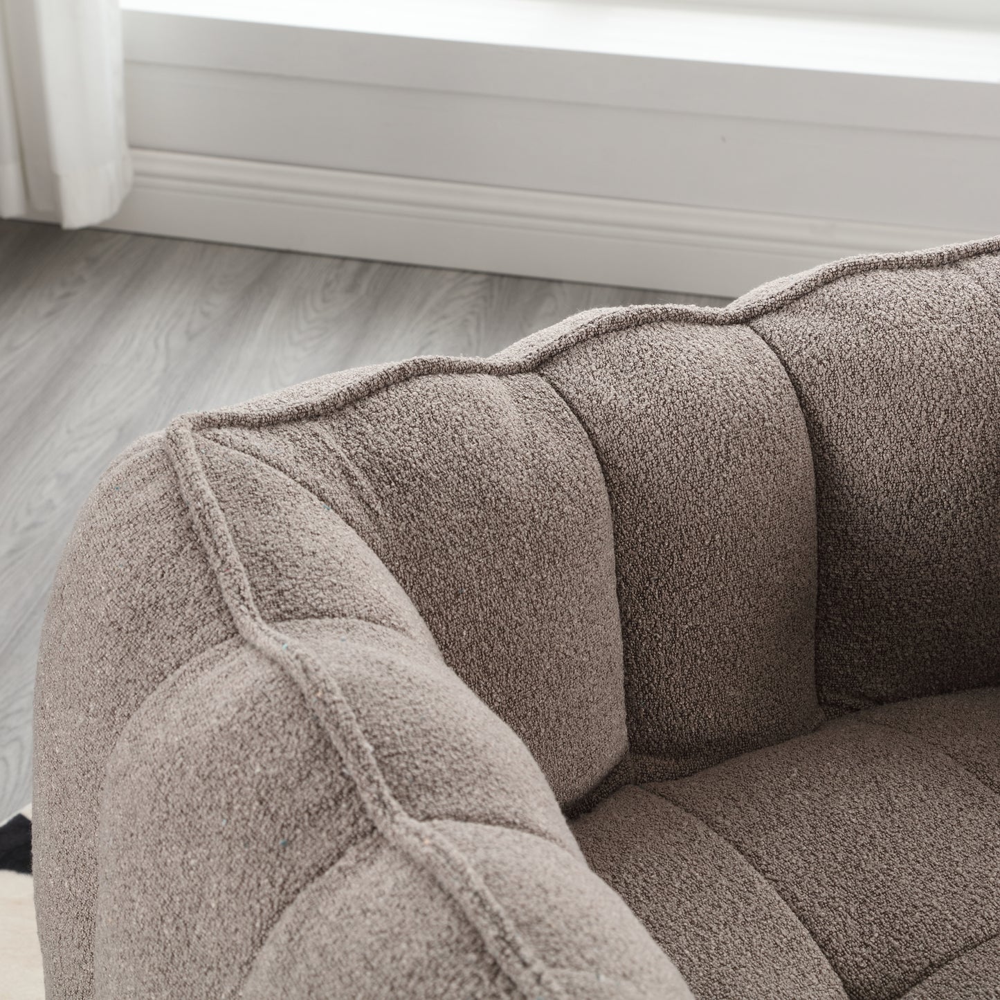 Taupe textured fabric armchair with tufted cushions perfect for a modern living room