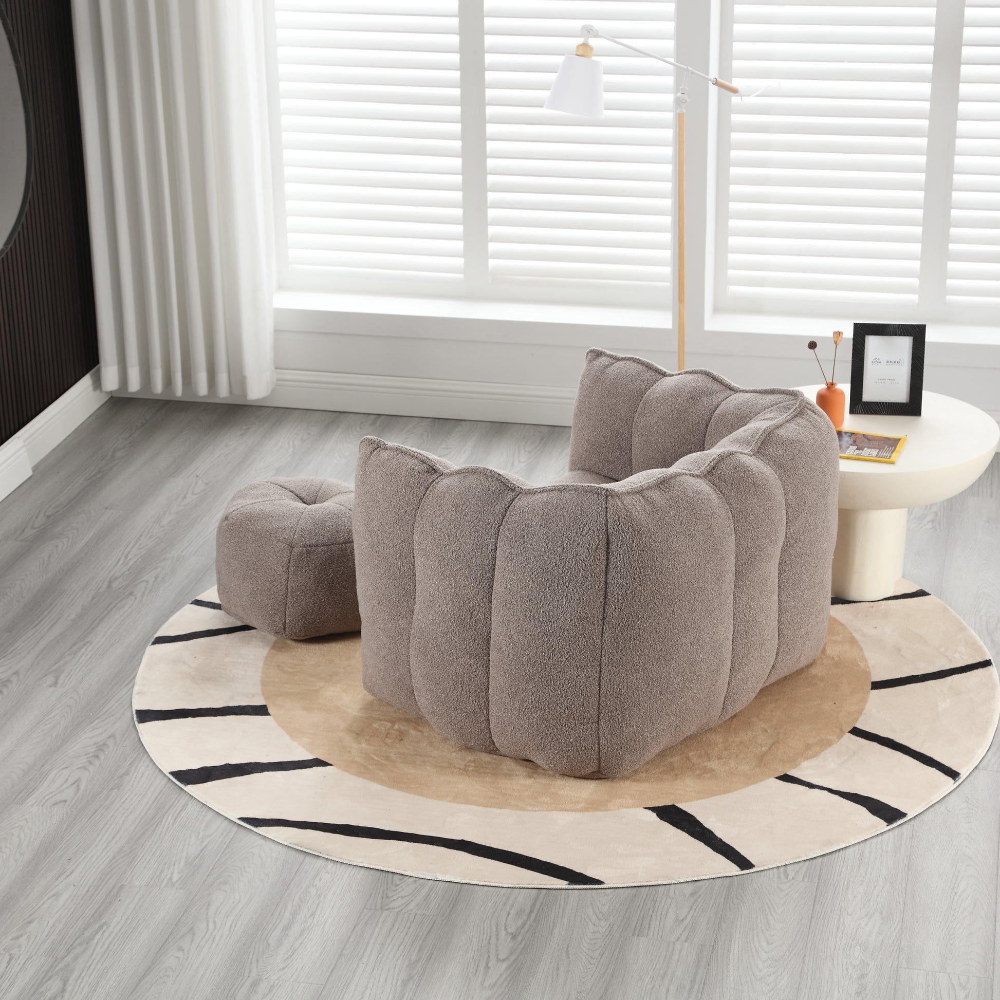 Plush taupe upholstered armchair with ribbed design and matching ottoman for modern living rooms