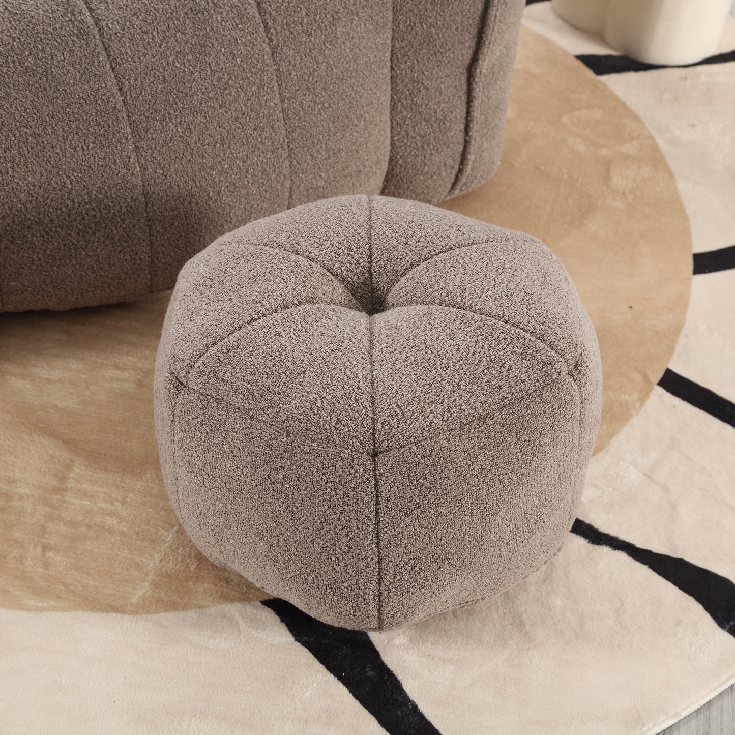 Plush taupe boucle fabric ottoman with tufted top perfect for adding comfort to living spaces