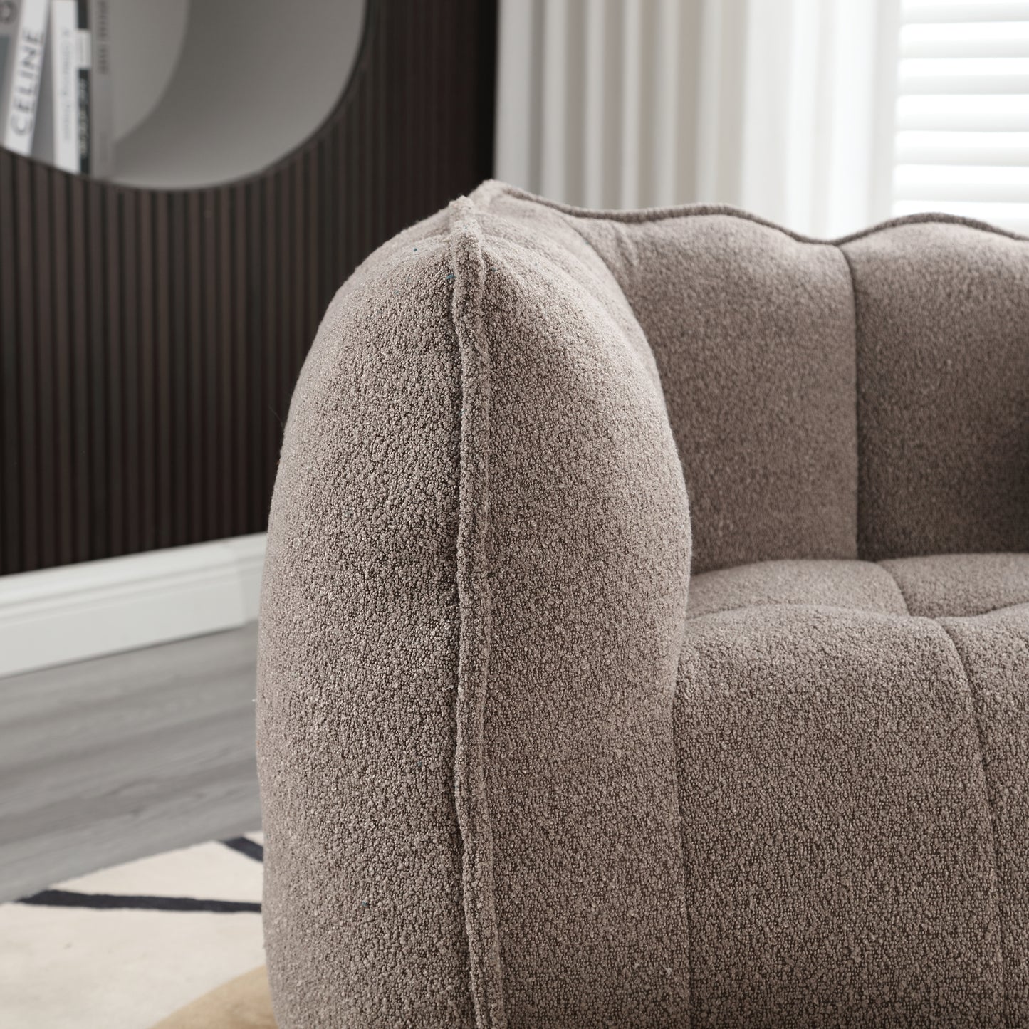 Plush teddy fabric armchair in warm taupe featuring channel tufting and a rounded armrest