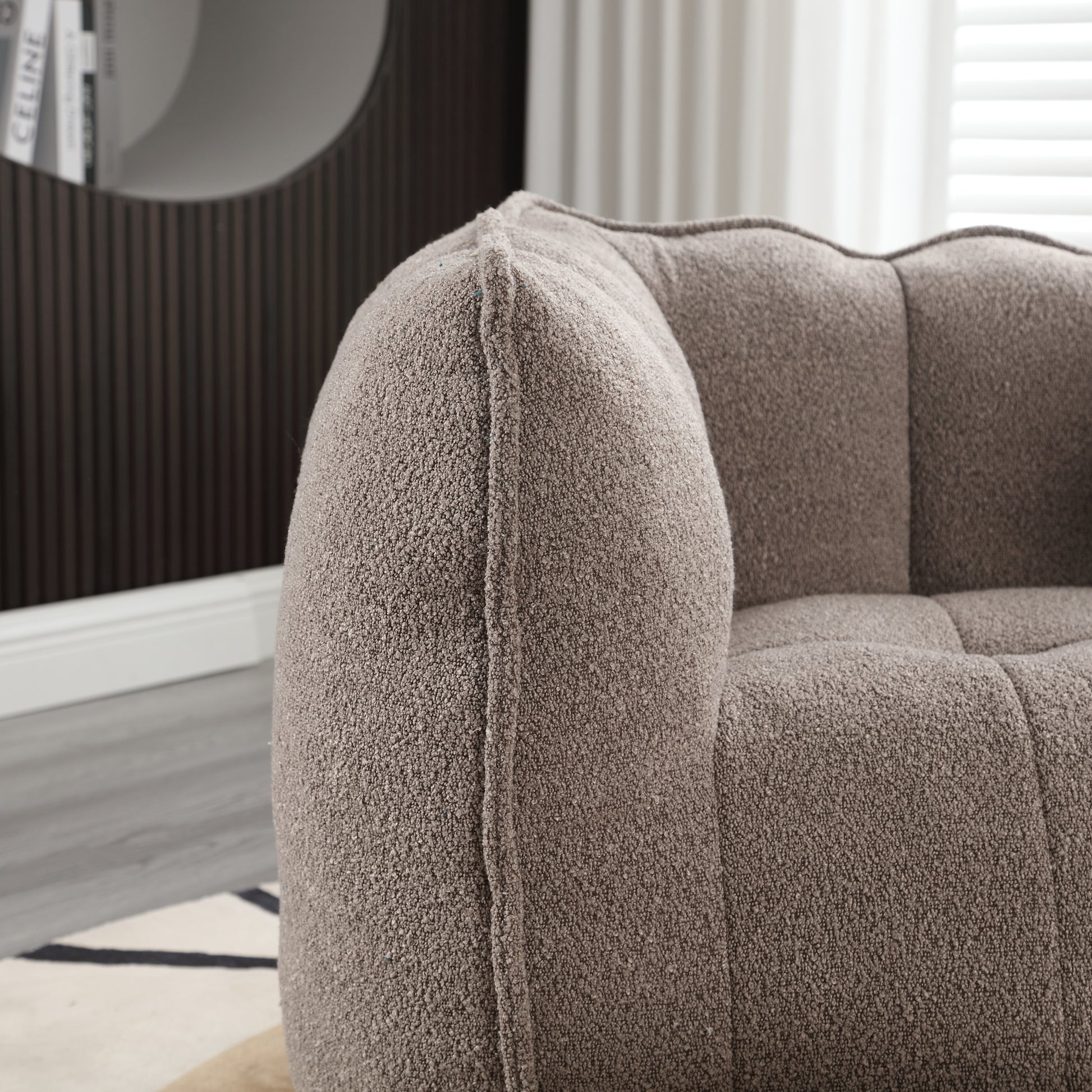 Plush teddy fabric armchair in warm taupe featuring channel tufting and a rounded armrest