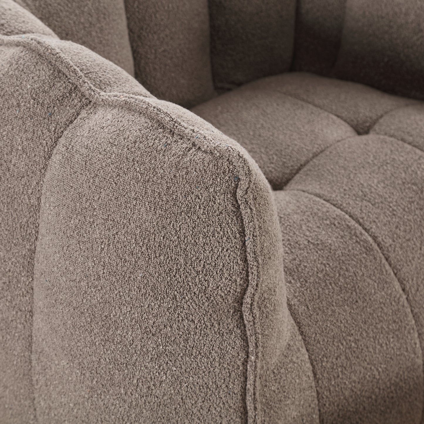 Closeup of textured boucle fabric armchair in taupe with channel tufting detail