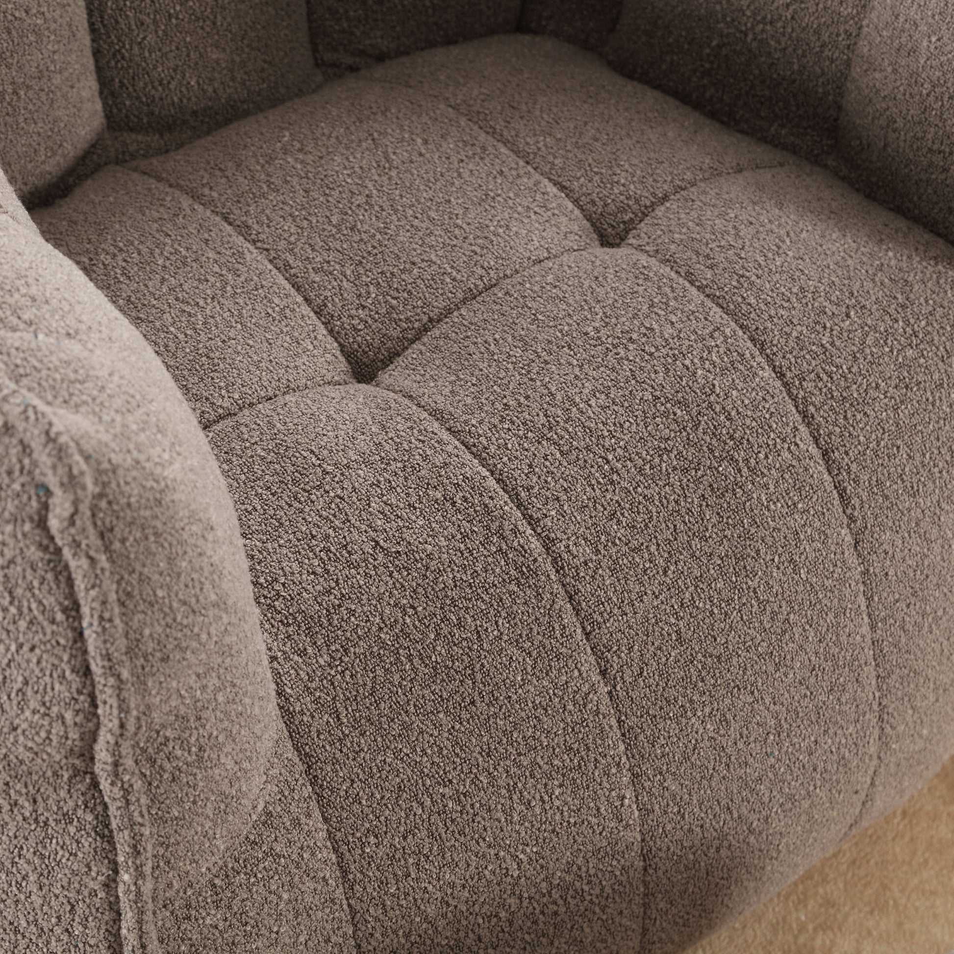 Brown boucle armchair detail with diamond tufting and plush armrest