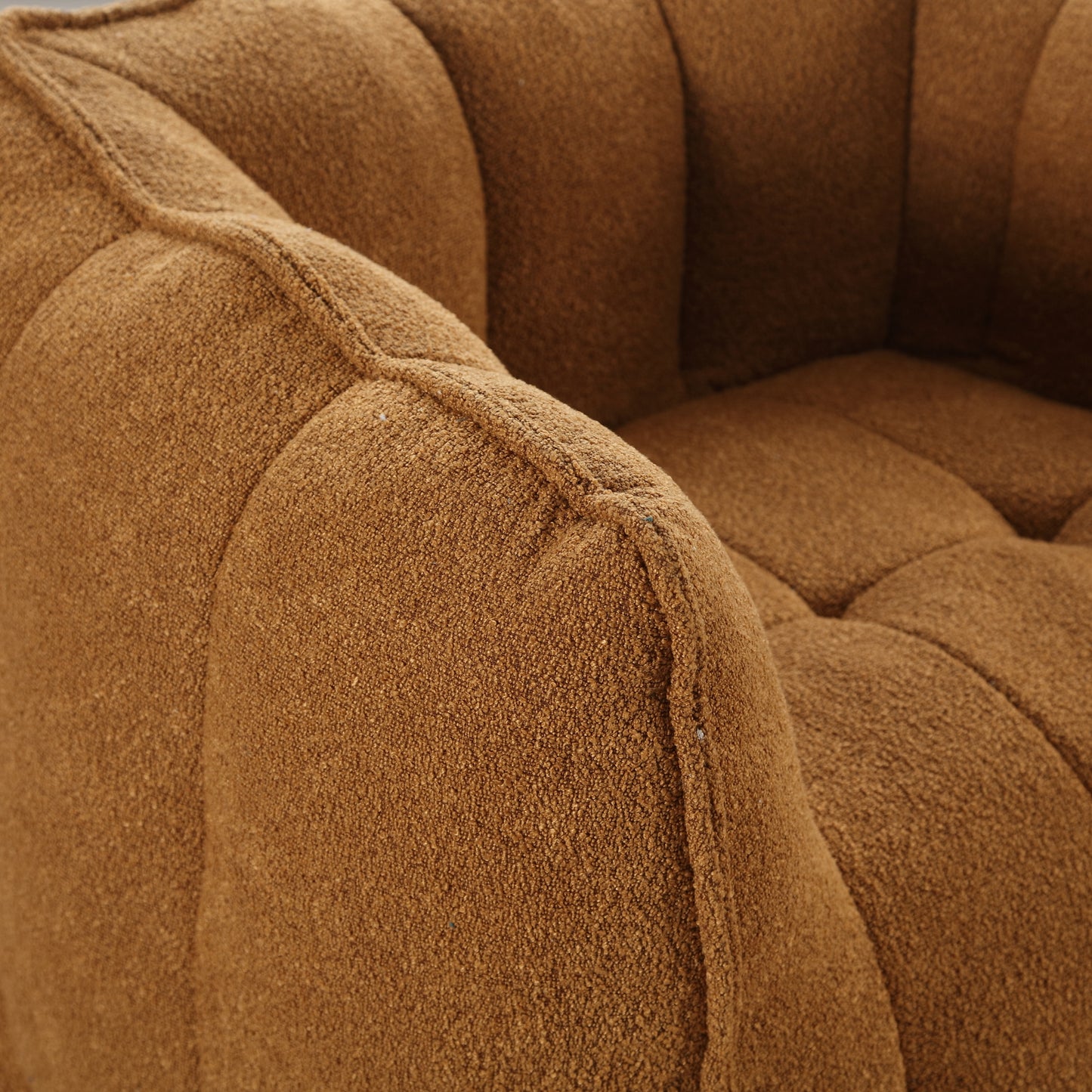 Tufted brown boucle armchair detail showcasing plush seating comfort
