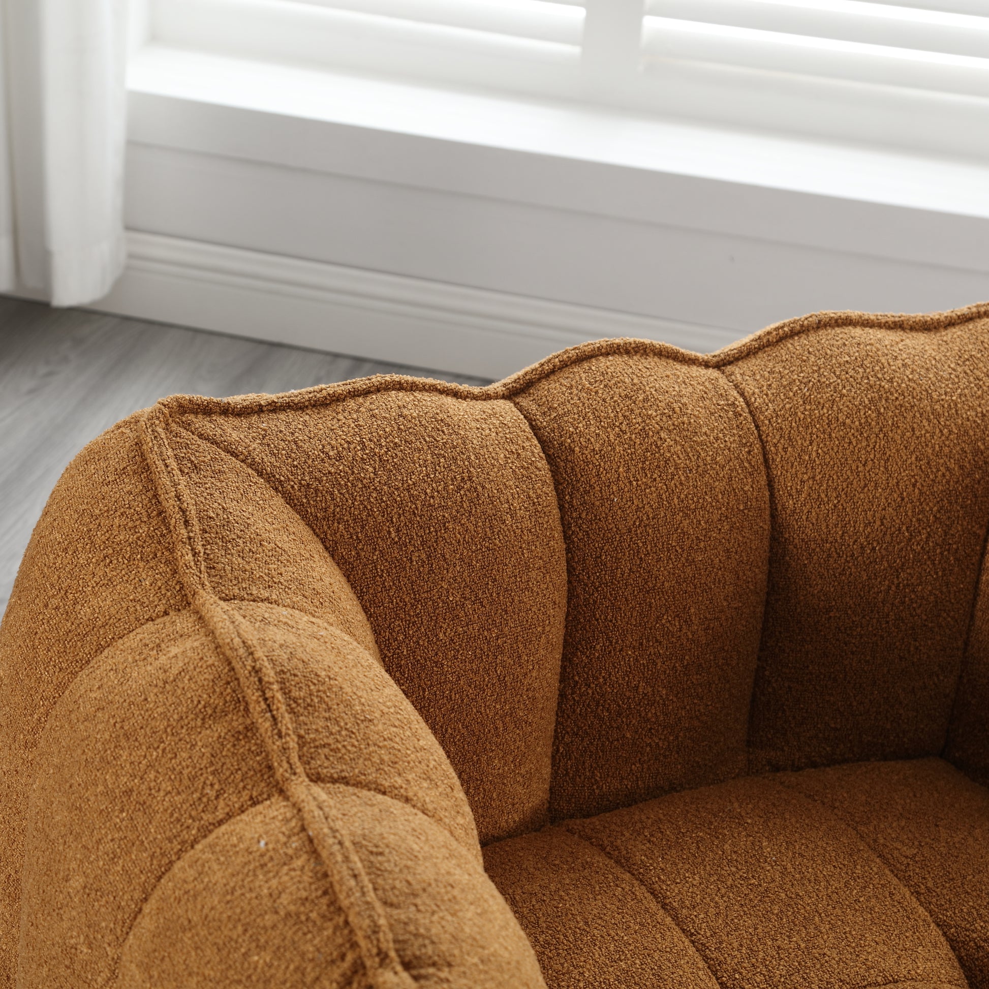 Closeup of plush brown boucle armchair detail with channel tufting