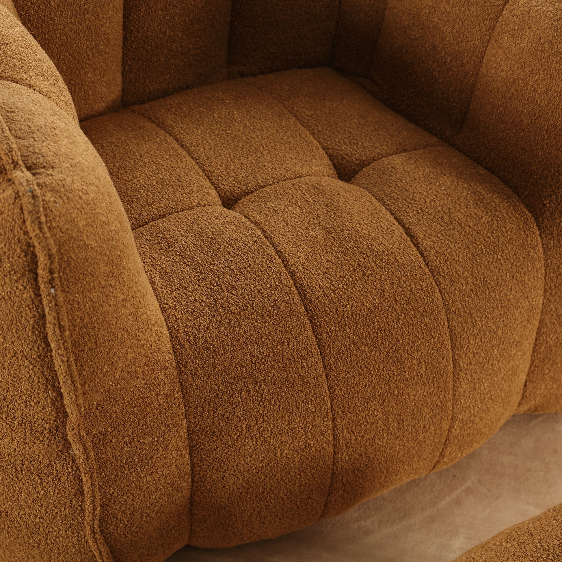 Closeup of plush brown boucle armchair seat with deep tufting