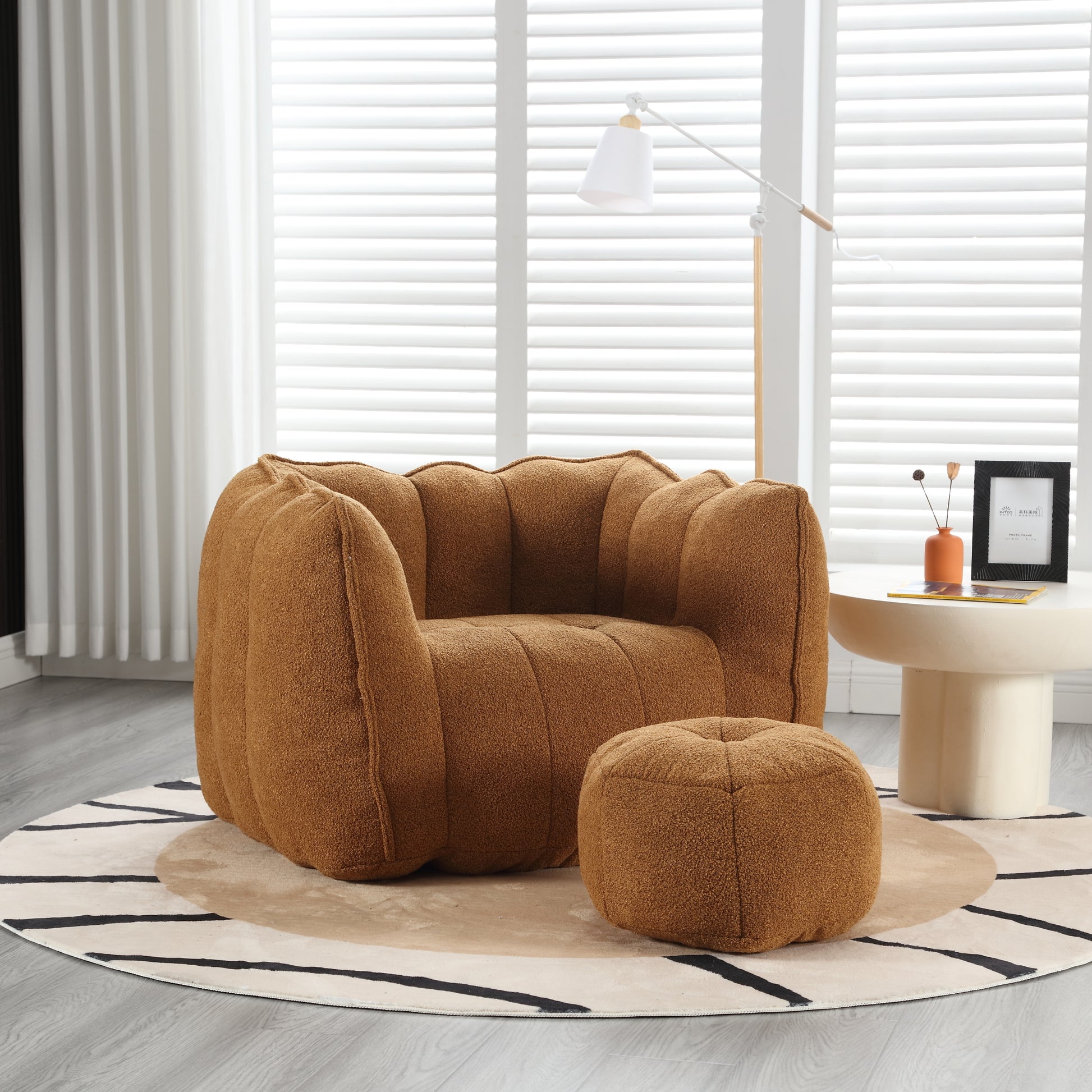 Plush brown armchair with unique scalloped back and matching ottoman on a modern rug