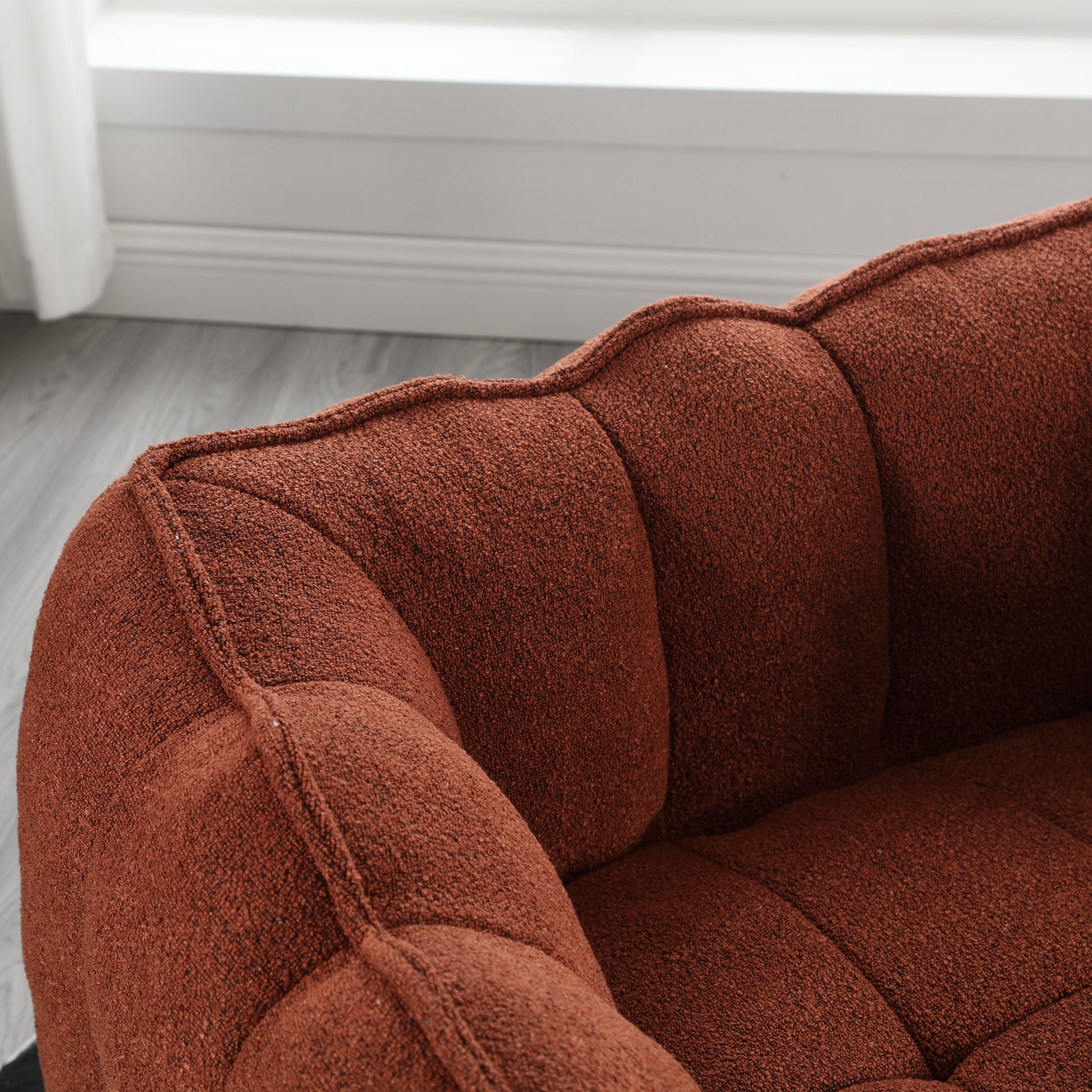 Tufted terracotta boucle accent chair with plush cushioning for comfortable seating