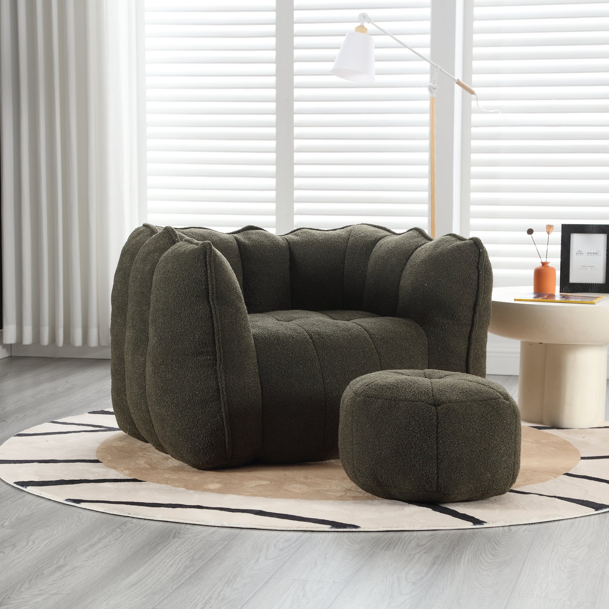 Plush dark green boucle fabric armchair with rounded tufted design and matching ottoman
