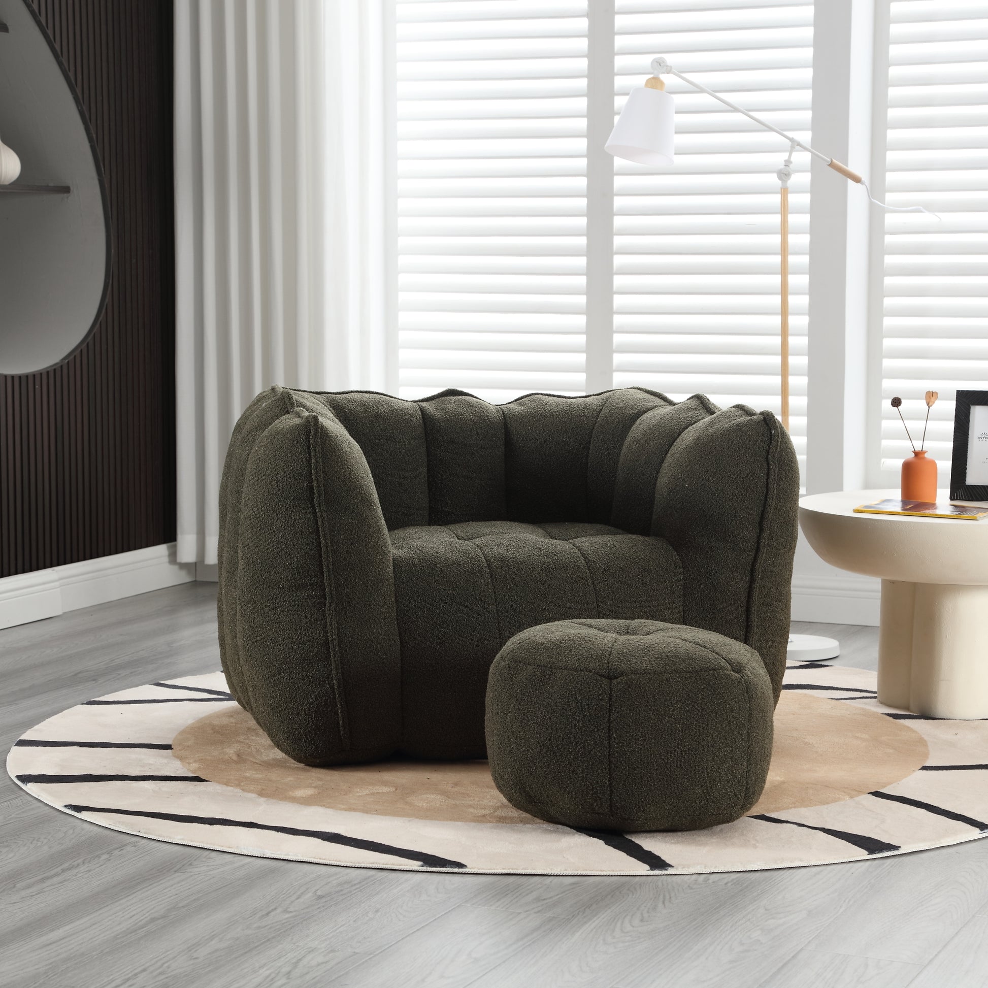 Dark green boucl armchair with button tufting and matching ottoman for cozy living room seating