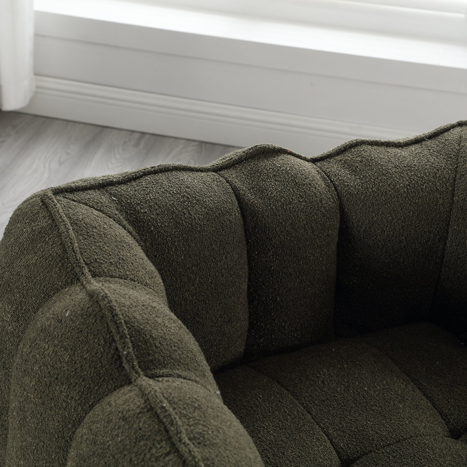 Dark green boucle fabric armchair with channel tufting for luxurious comfort