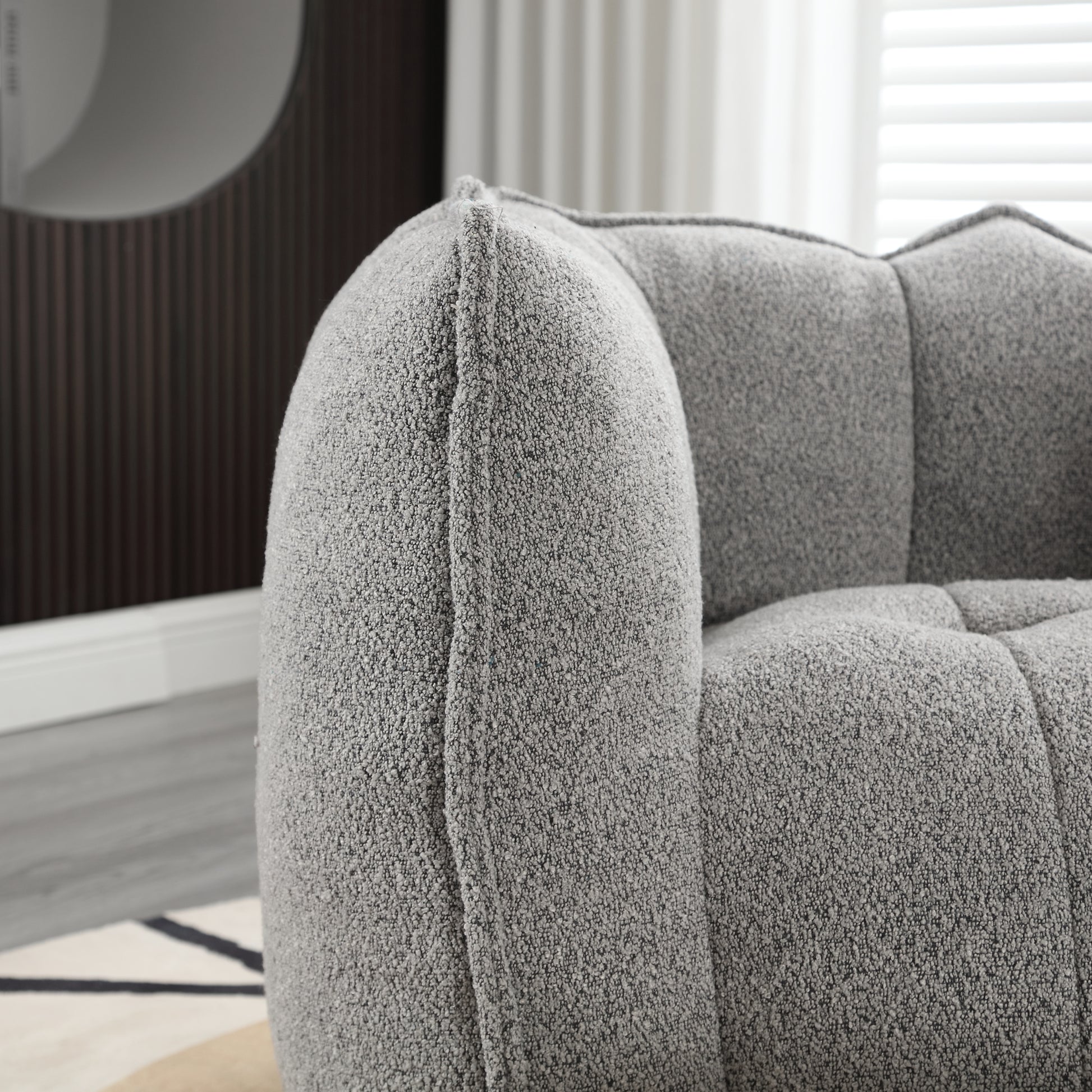 Textured grey boucle fabric armchair with plush cushions for comfortable seating