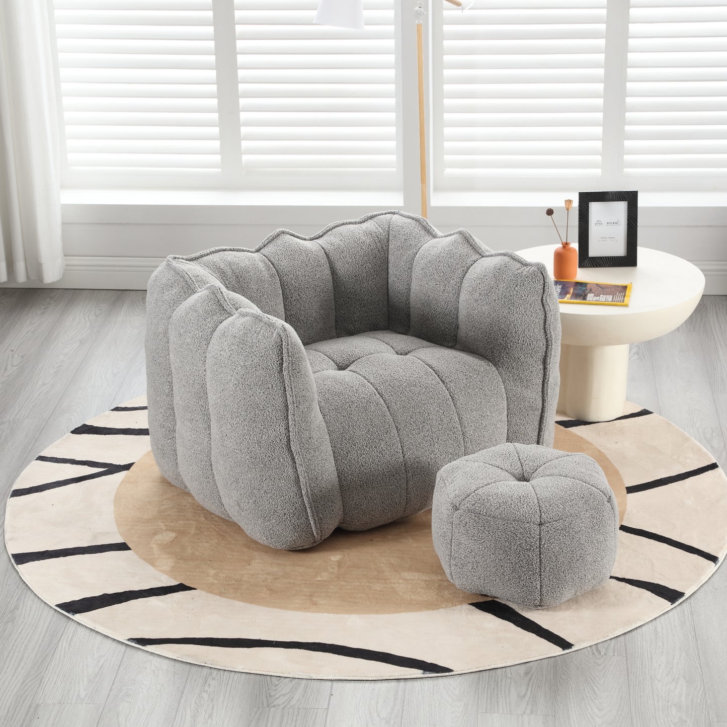 Textured gray boucl armchair with rounded petallike arms and a matching ottoman