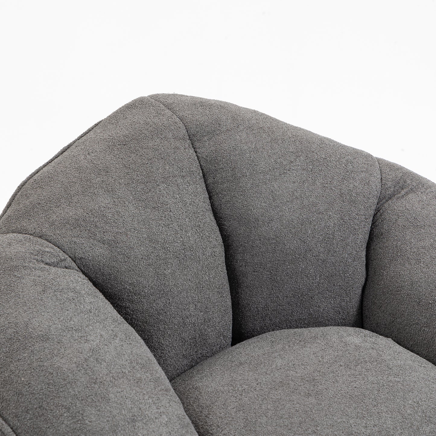 Plush grey fabric armchair detail with curved tufted cushioning for ultimate comfort