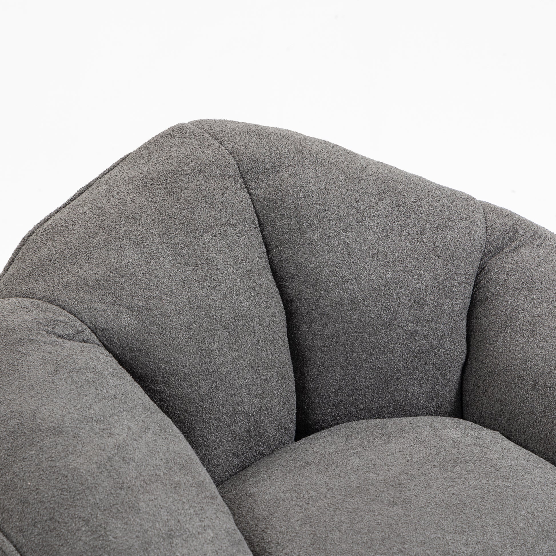 Plush grey fabric armchair detail with curved tufted cushioning for ultimate comfort