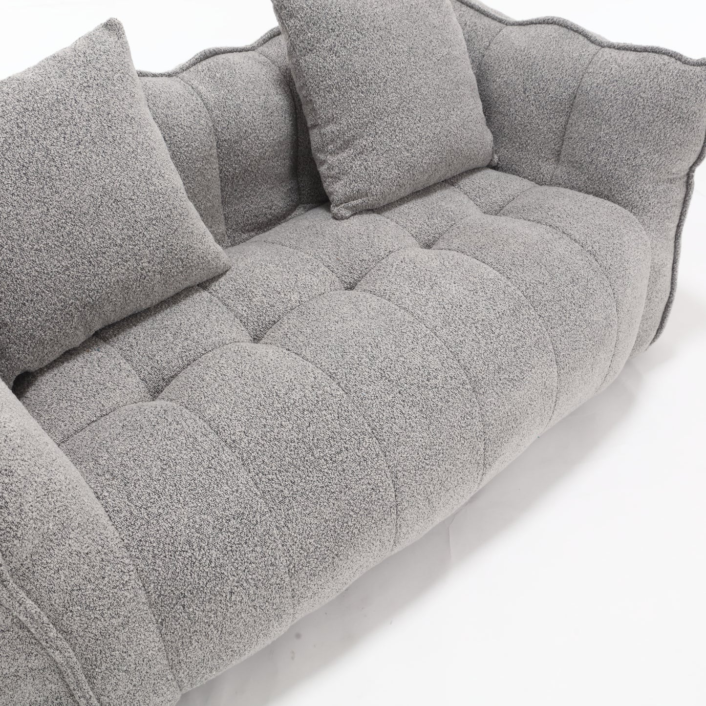 Gray boucle fabric sofa with tufted seat cushions and plush throw pillows
