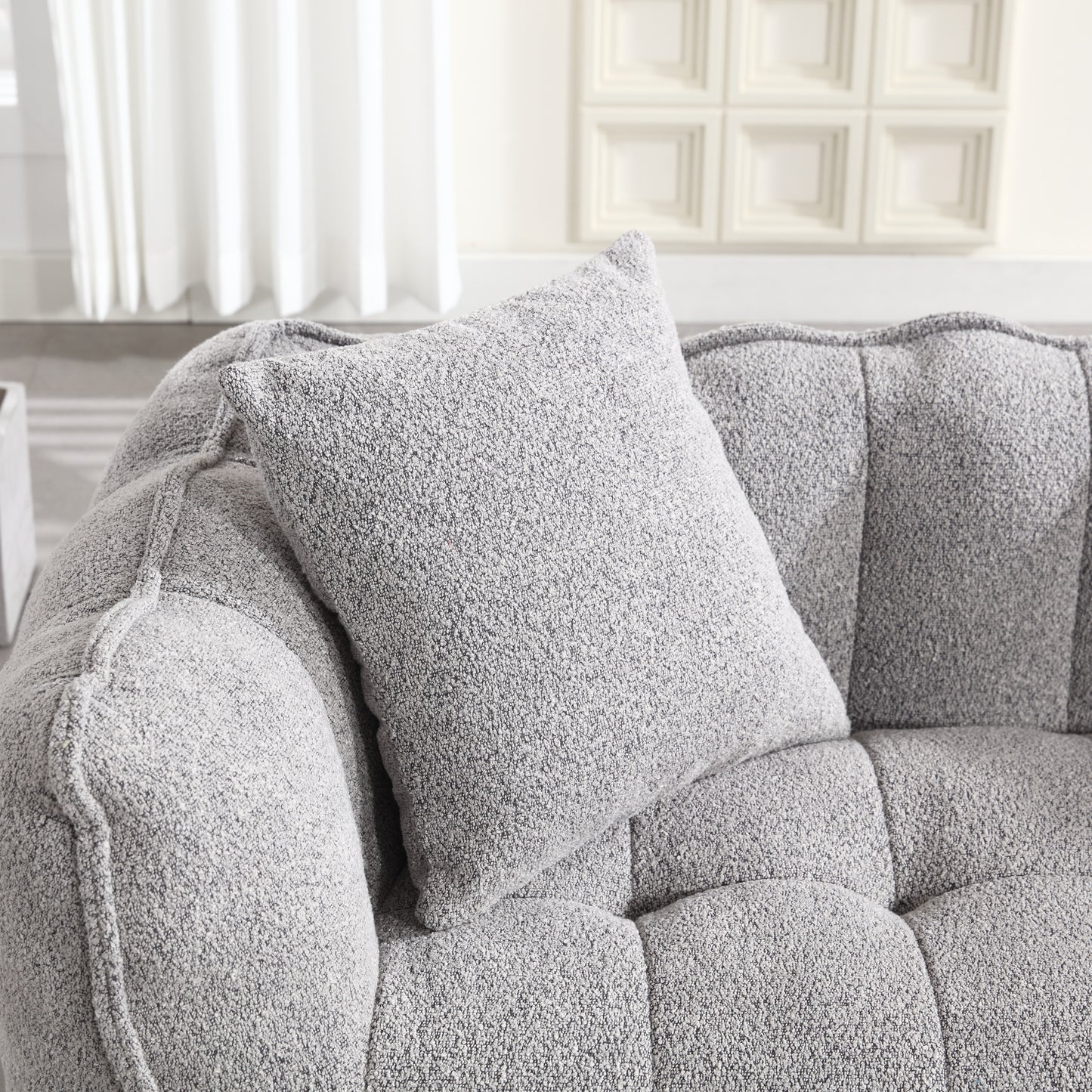 Textured grey throw pillow on a plush tufted sofa perfect for modern living rooms