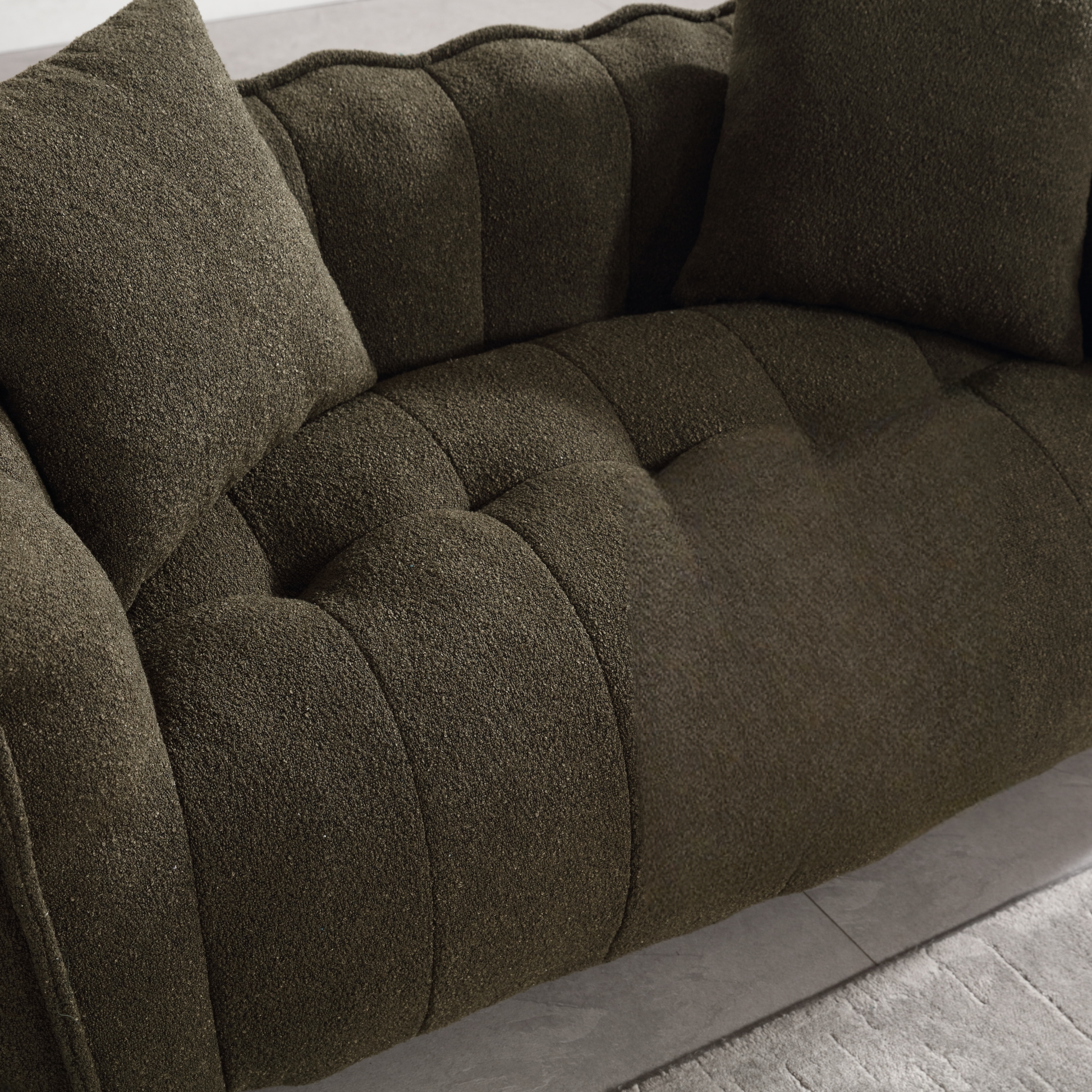 Deep green textured sofa with tufted seat and matching pillows