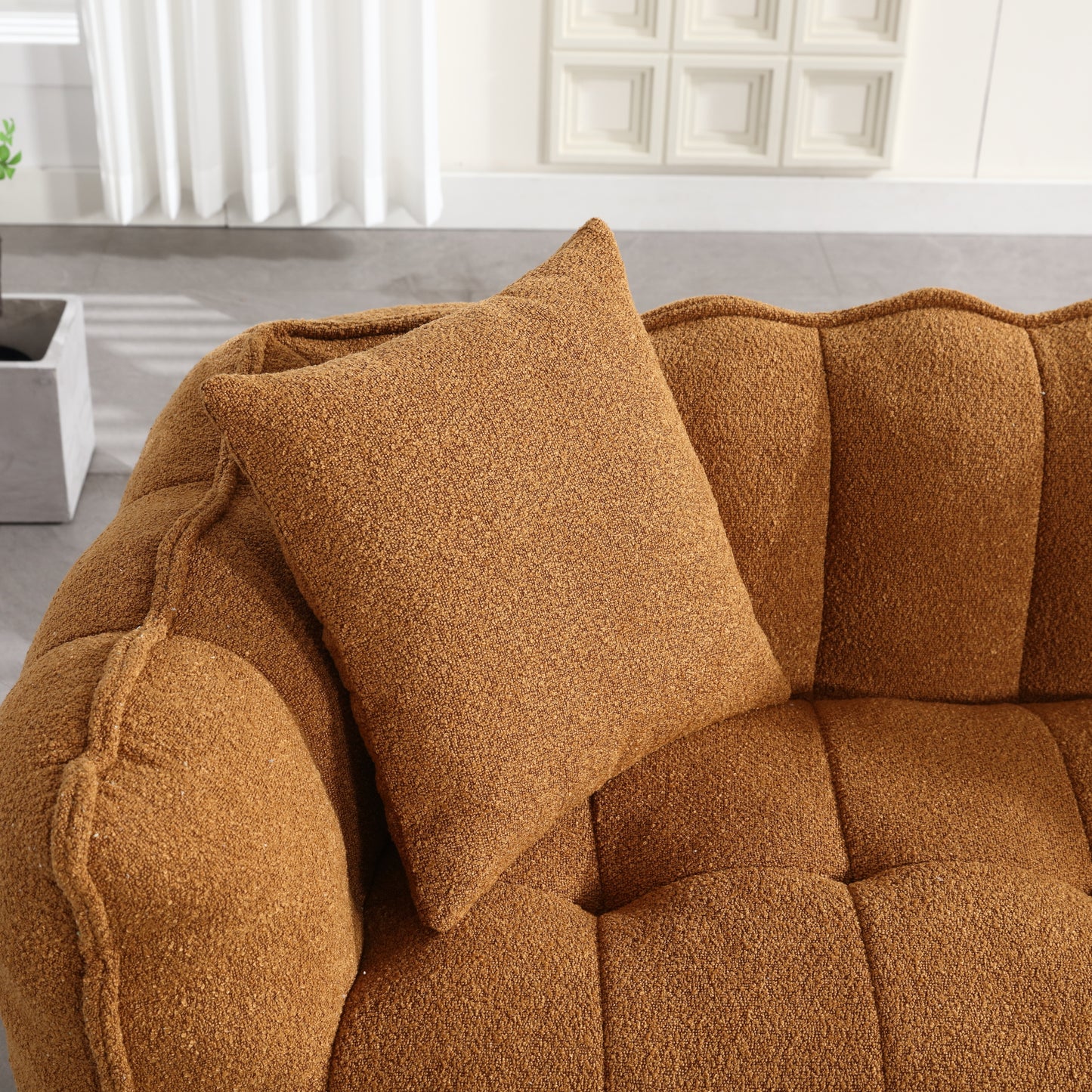 Brown textured boucle fabric accent pillow on a matching sofa