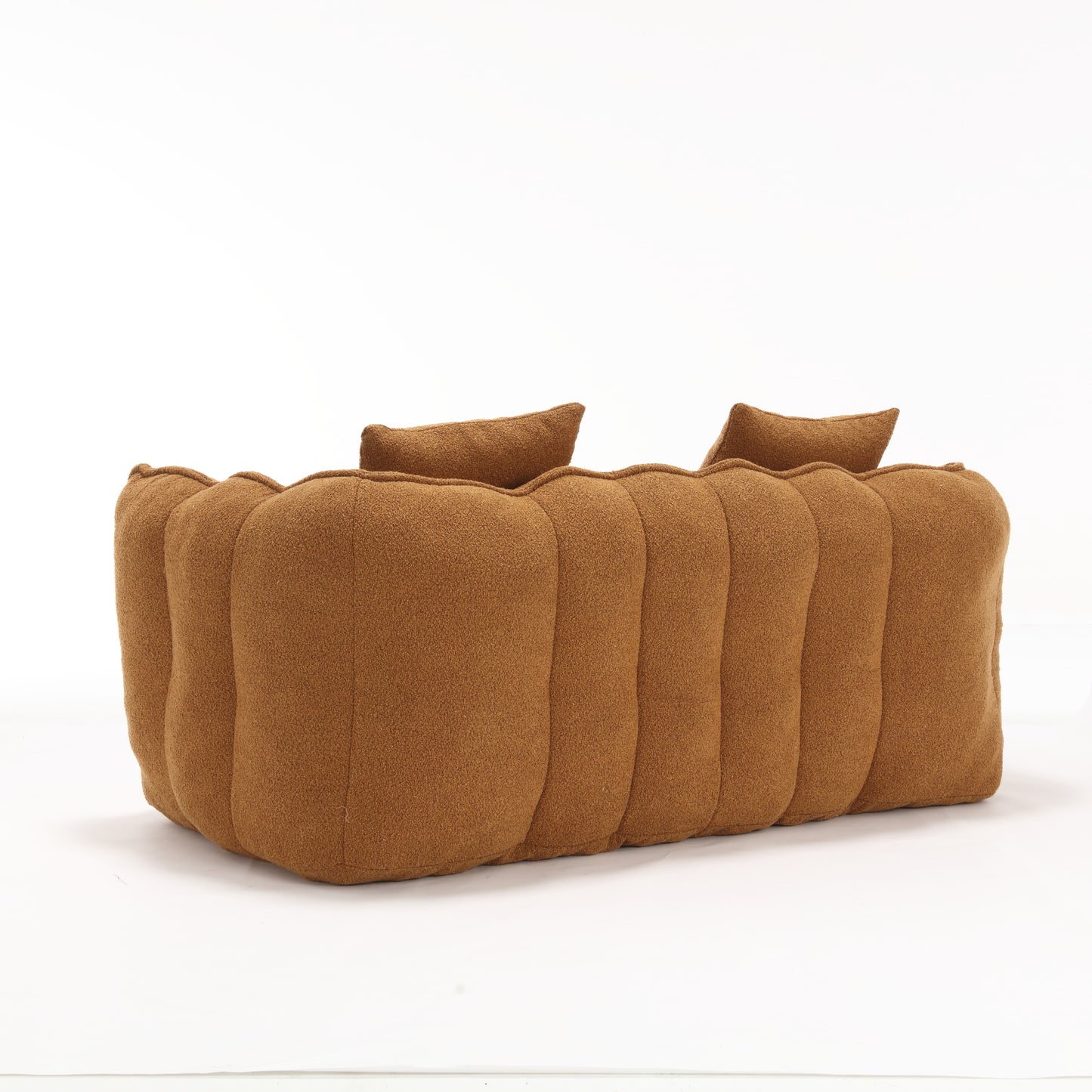 Puffy caramel boucle fabric sofa with curved seams and accent pillows