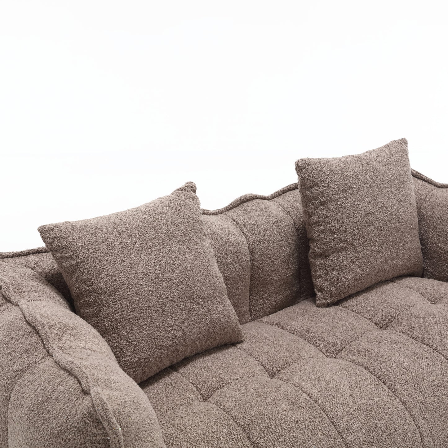 Plush taupe boucle fabric sofa with tufted seat cushions and textured throw pillows