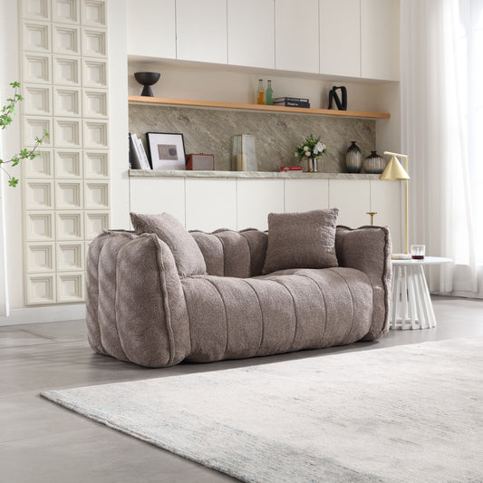 Plush taupe fabric sofa with channel tufting and accent pillows for a modern living room