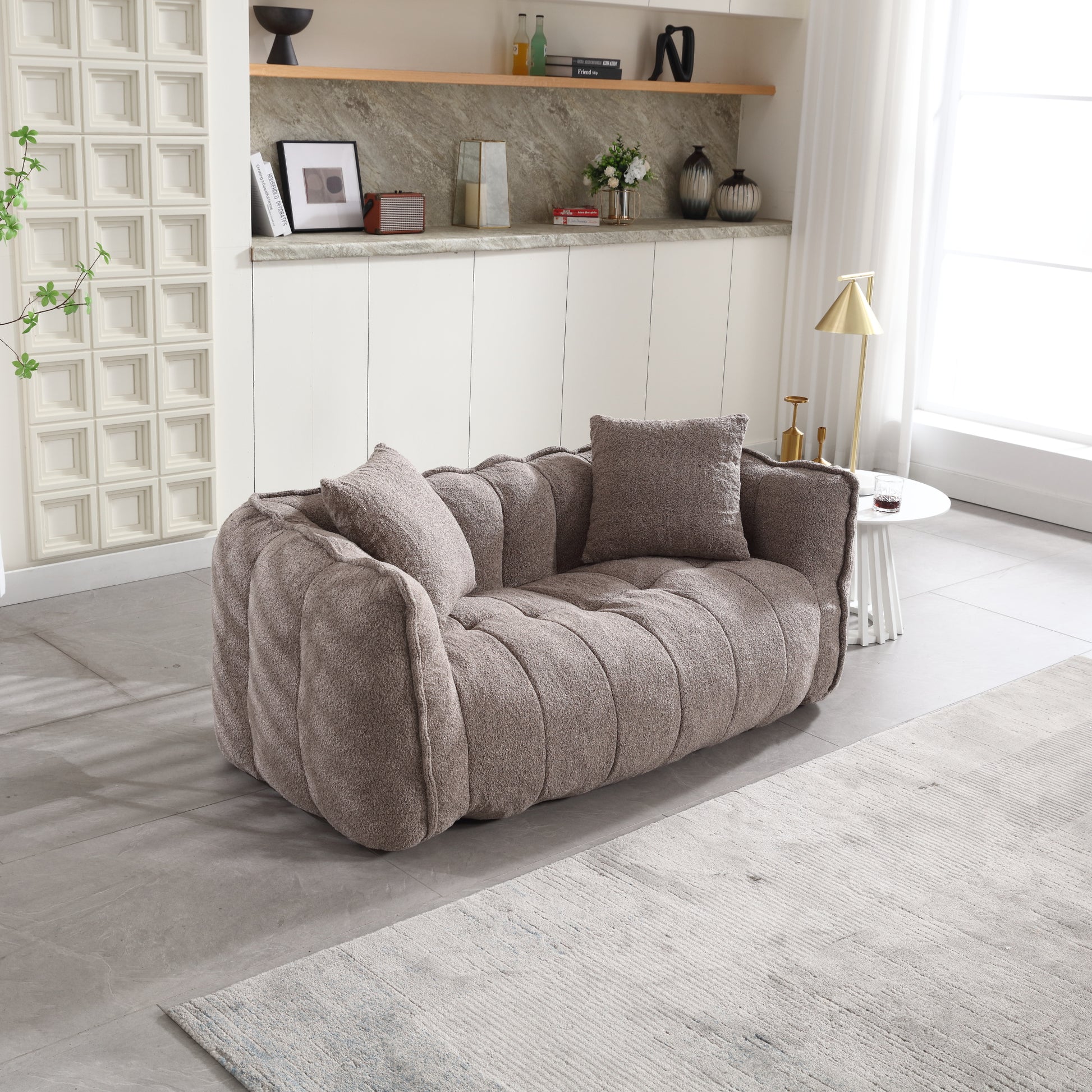 Plush taupe boucle sofa with channel tufting and matching throw pillows perfect for a modern living room