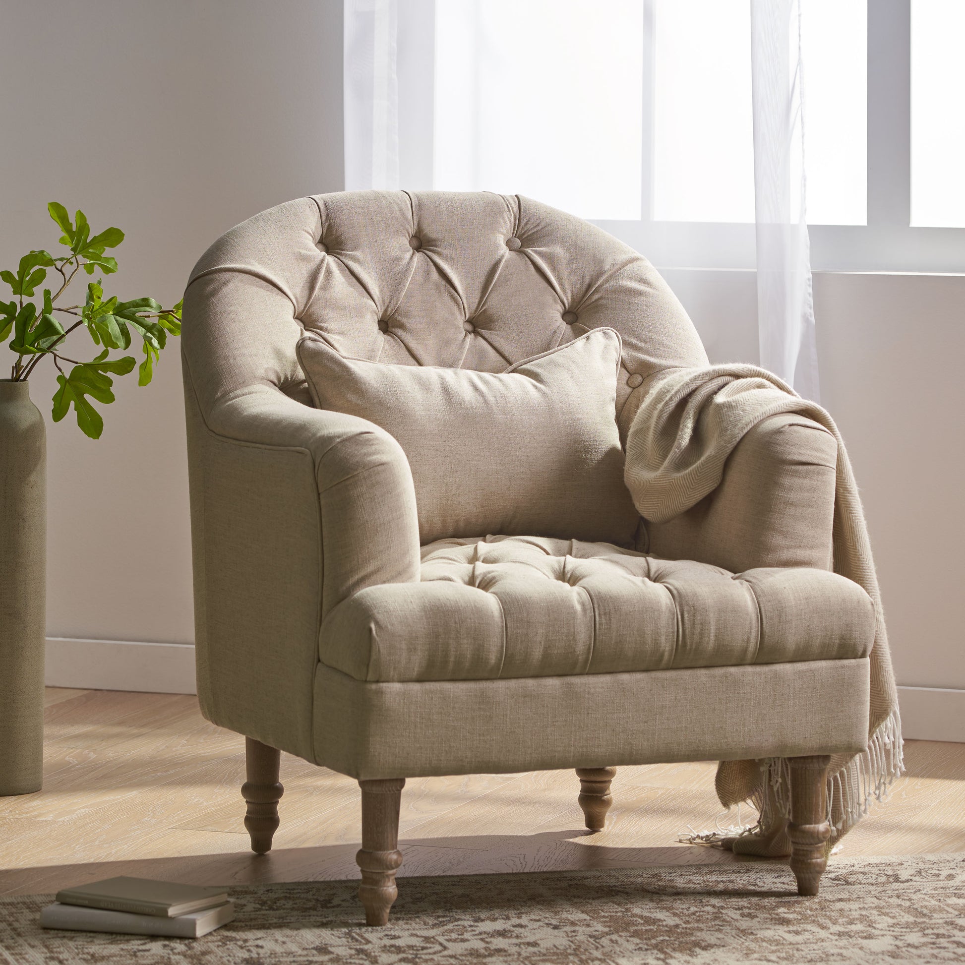 Tufted beige linen accent chair with rolled arms and decorative wooden legs