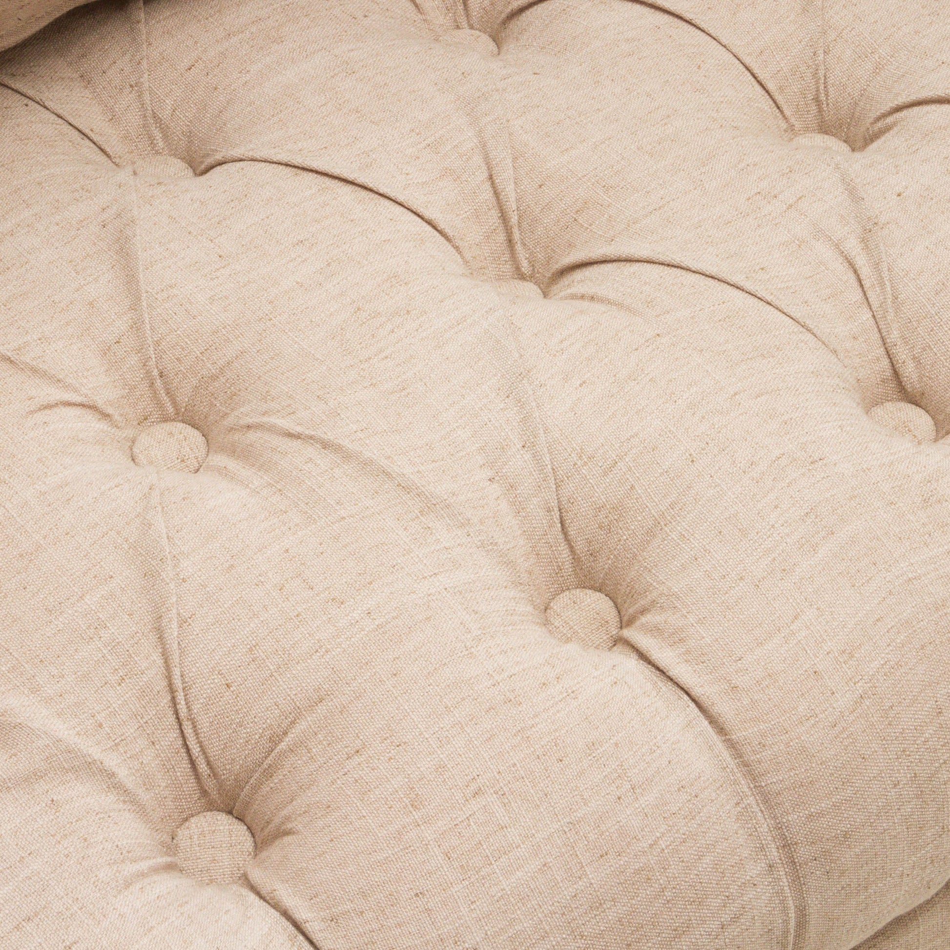 Closeup of tufted beige linen upholstery with button accents perfect for furniture