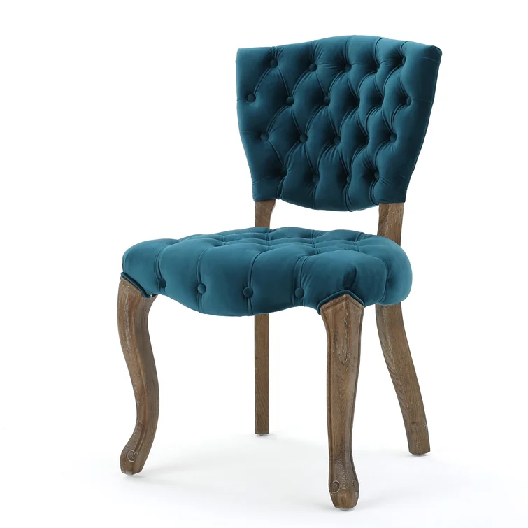 Teal velvet accent chair with button tufting and ornate wooden legs