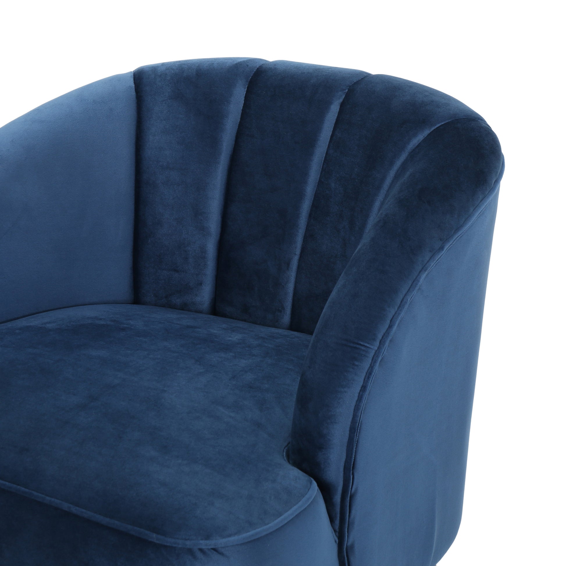 Closeup of a deep blue velvet armchair with channel tufting on the backrest