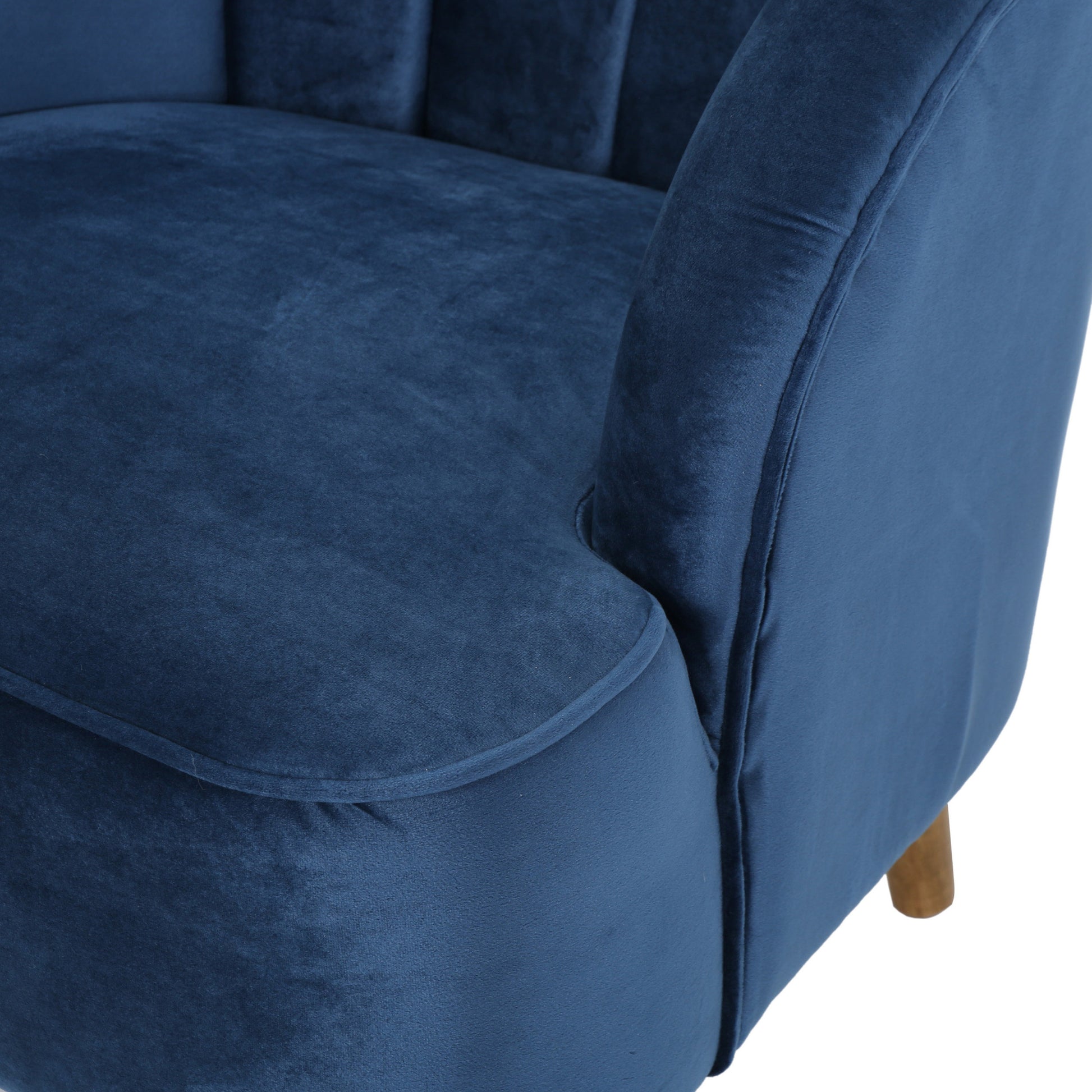 Deep blue velvet armchair with plush seating and channeled backrest