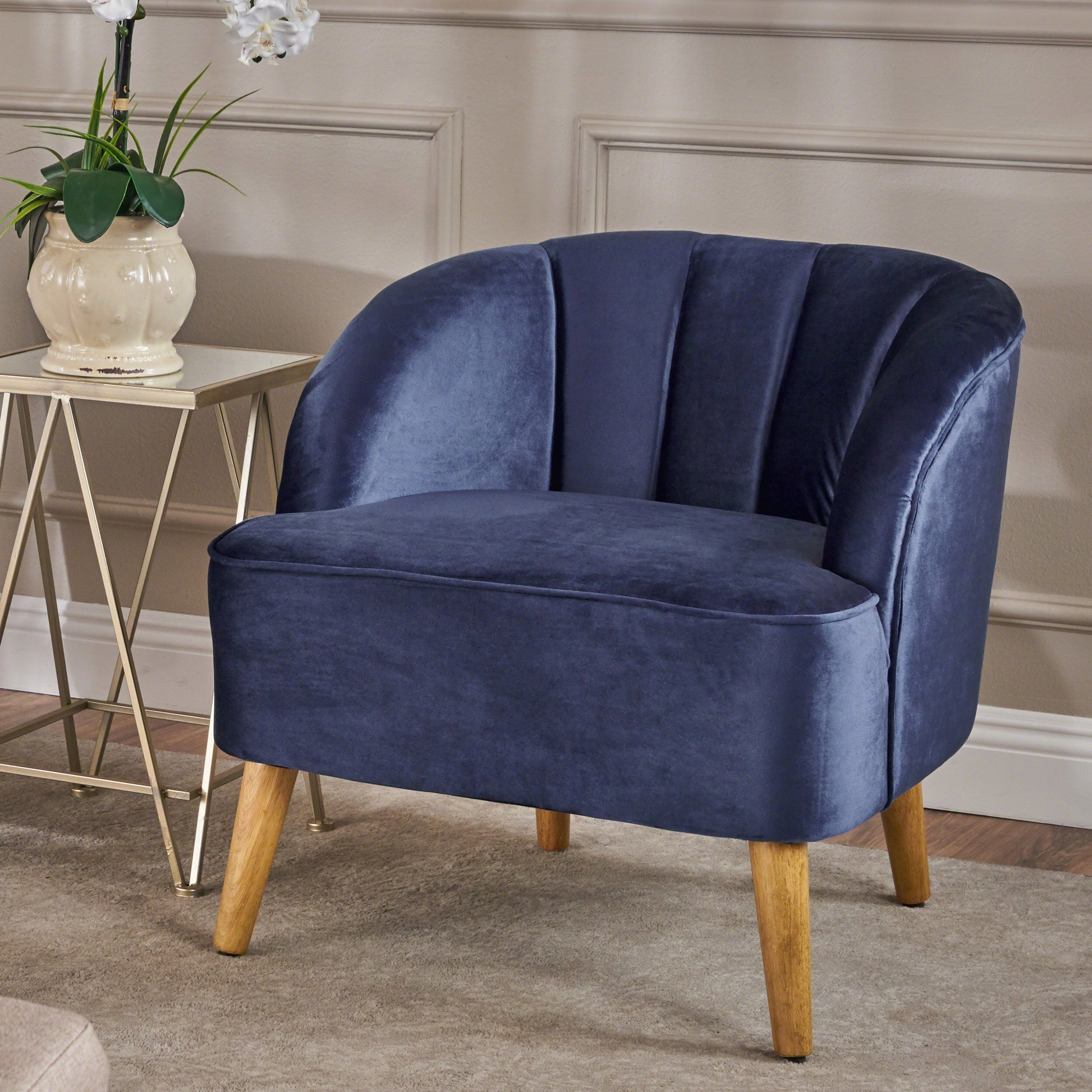 Dark blue velvet accent chair with channel tufting and wooden legs perfect for living rooms