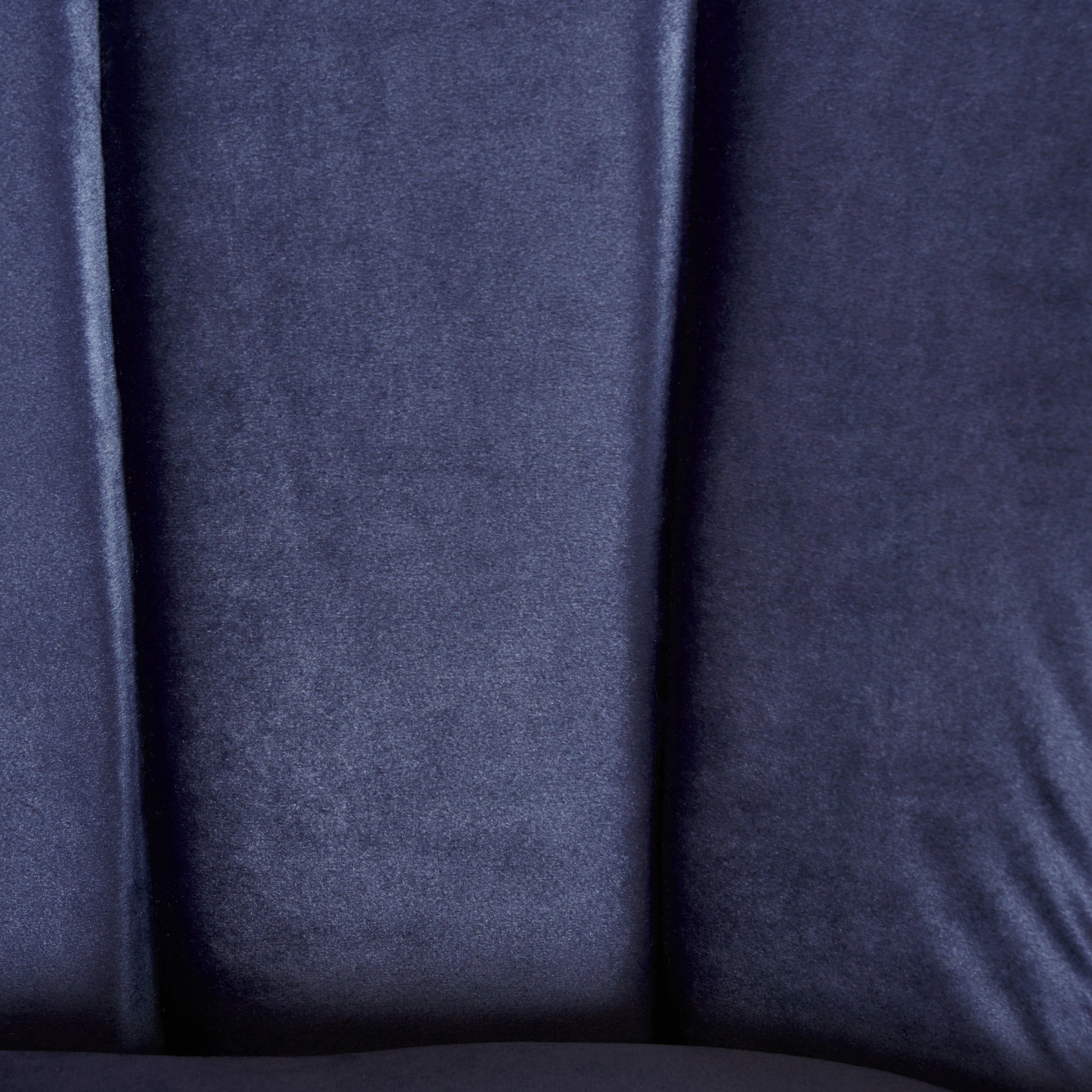 Closeup of deep navy blue satin fabric with subtle sheen and folds