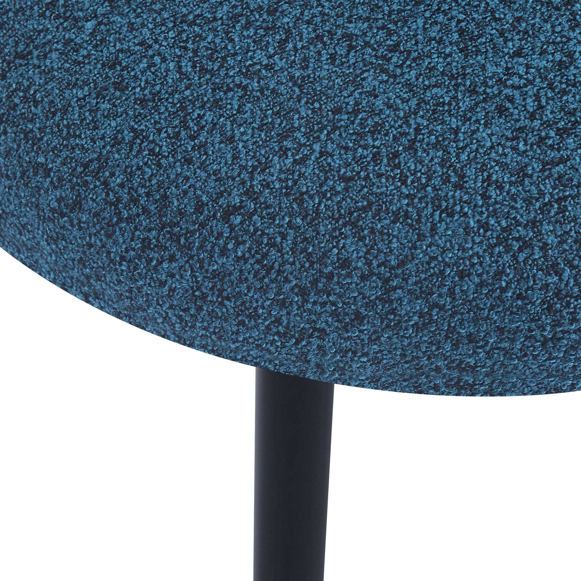 Textured teal upholstery detail on a modern stool with a black metal leg